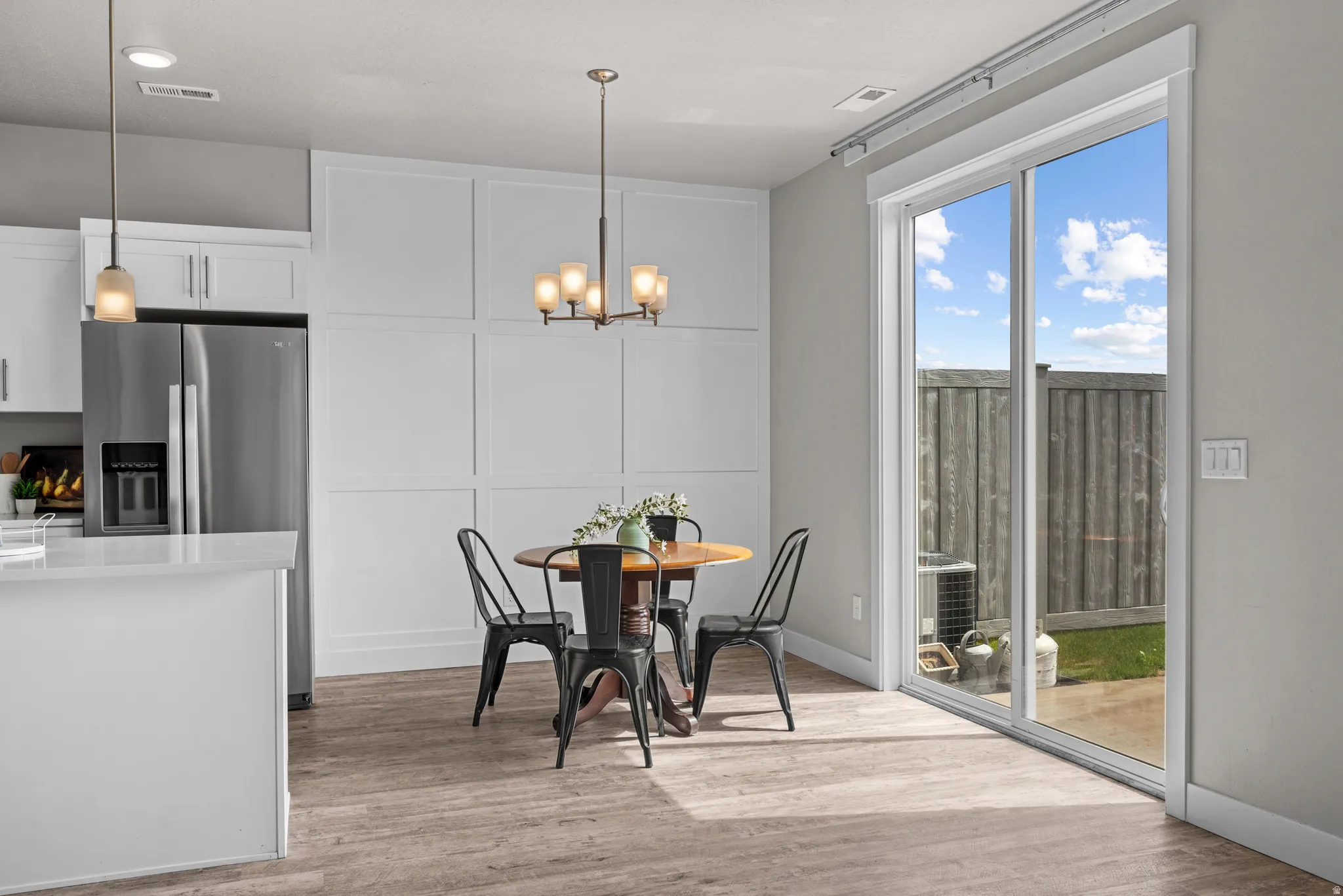 Dining area with light wood finished floors and a chandelier