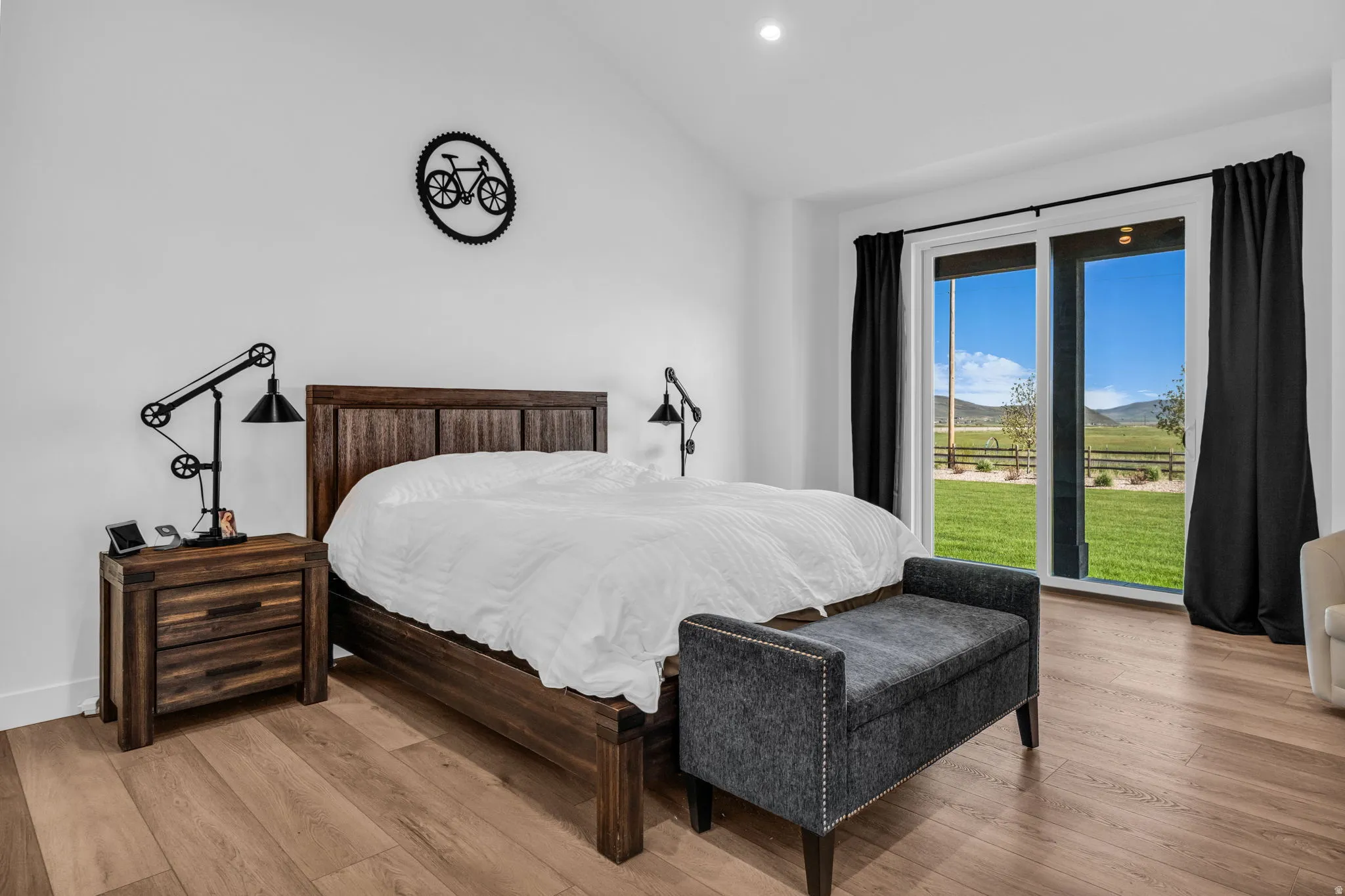Spacious room featuring light wood-finish flooring, white walls, and a recessed ceiling light
