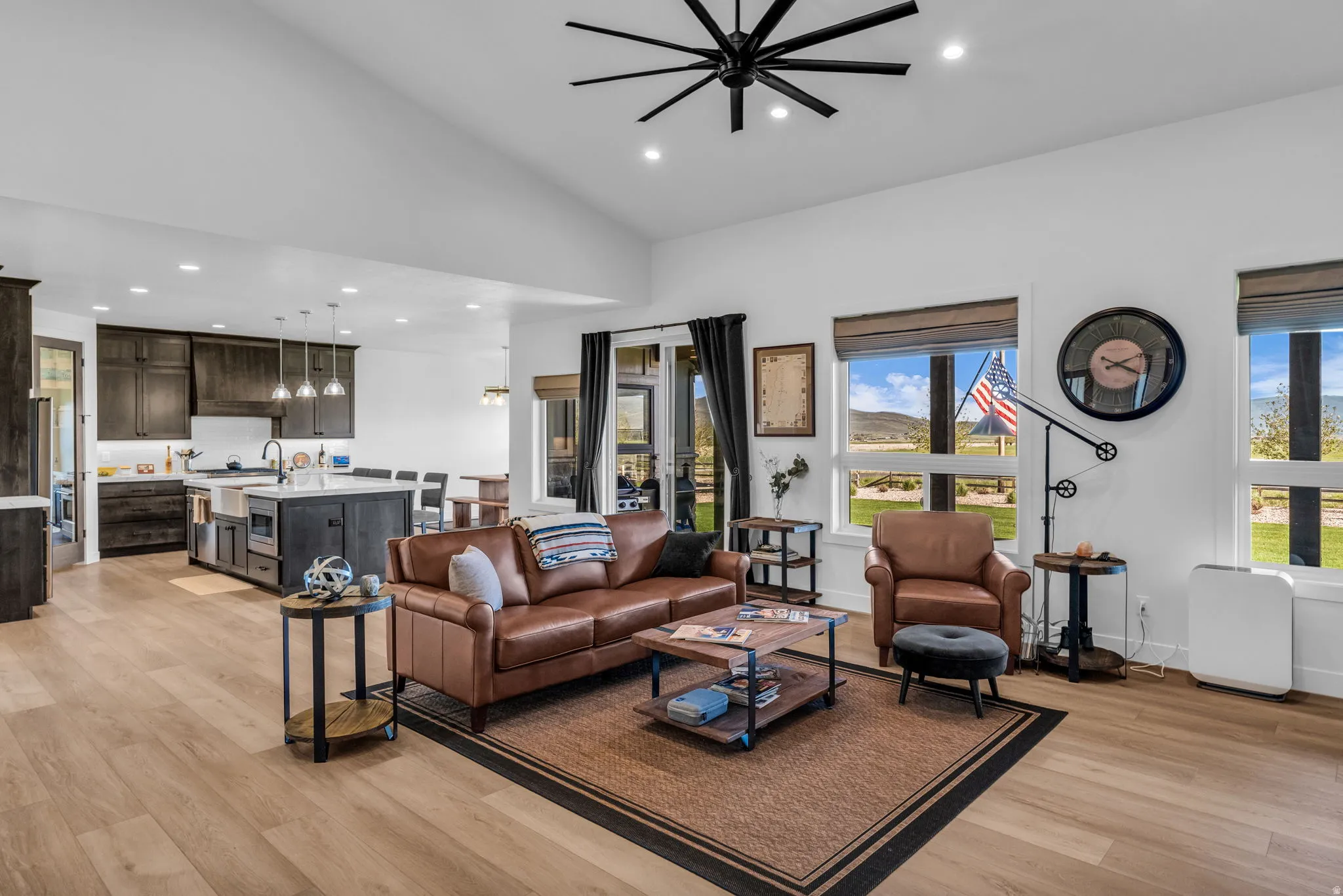 Open-concept living space featuring wood-finish flooring, vaulted ceilings, and recessed lighting