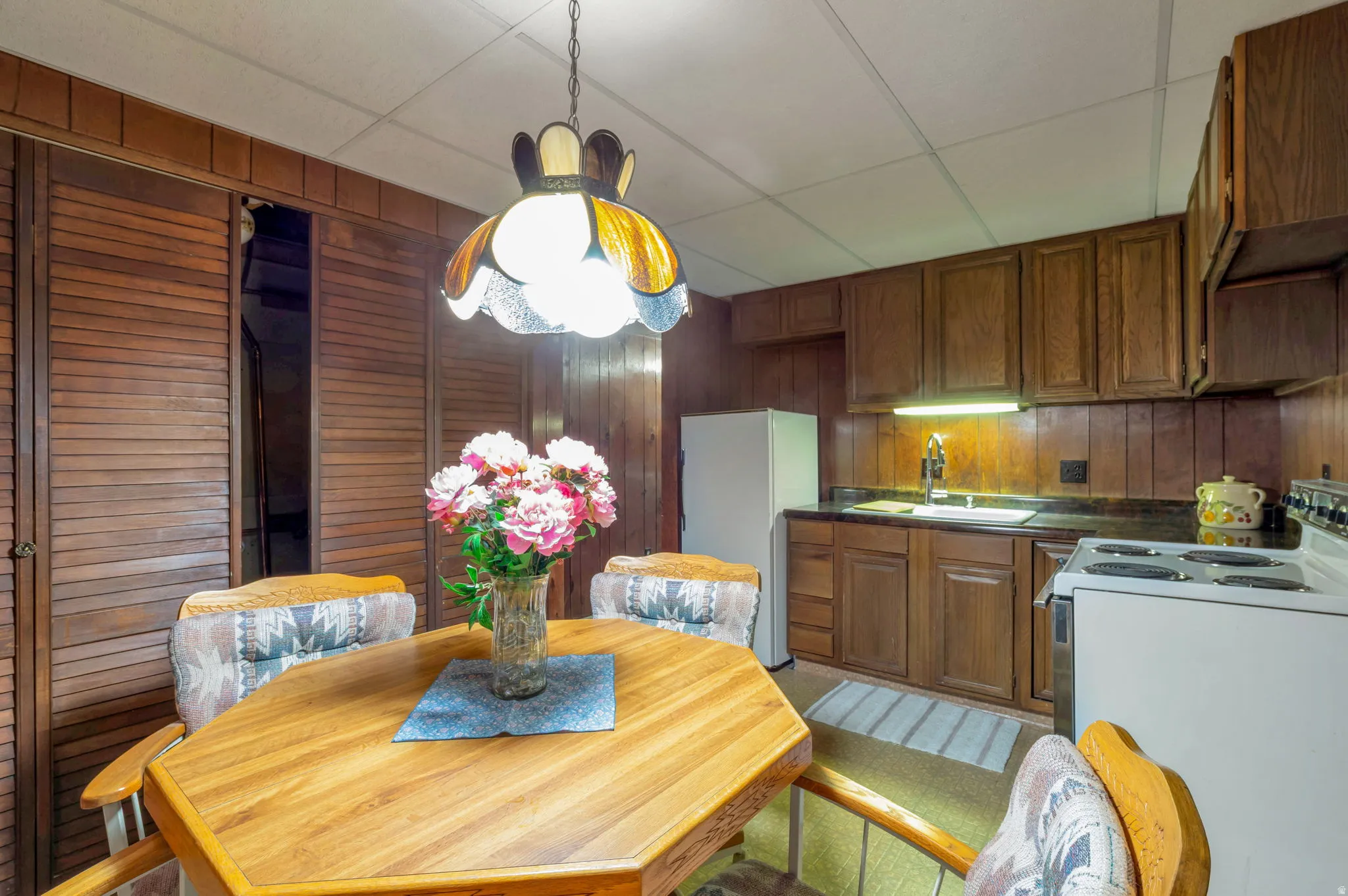 Dining room featuring wooden walls and a paneled ceiling