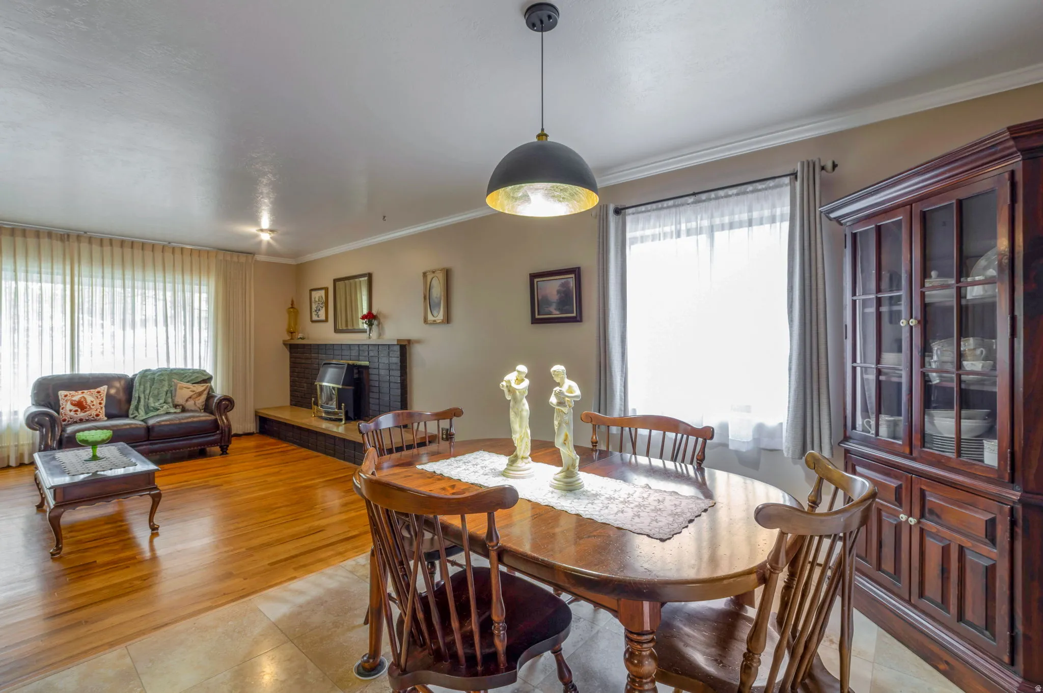 Dining space with ornamental molding, light tile patterned flooring, and healthy amount of natural light