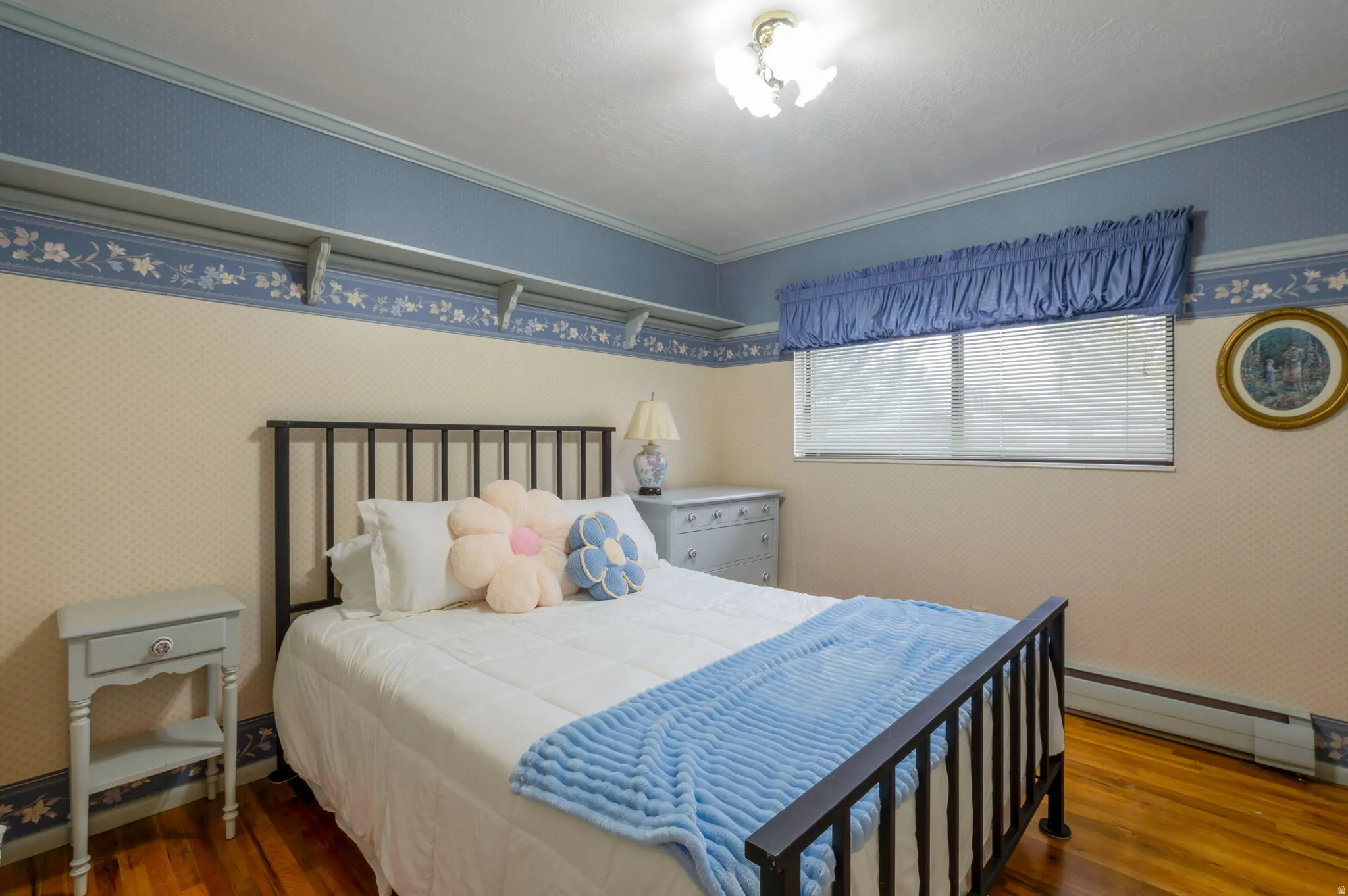 Bedroom featuring wallpapered walls, a baseboard radiator, dark wood-style flooring, and ornamental molding