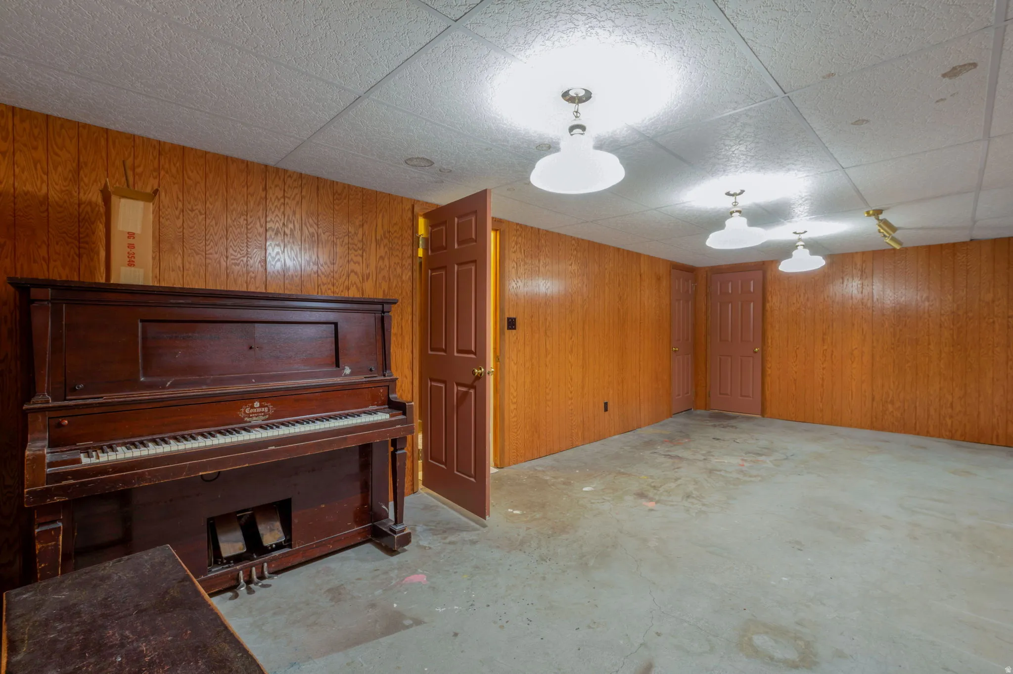 Finished below grade area with wooden walls and a drop ceiling