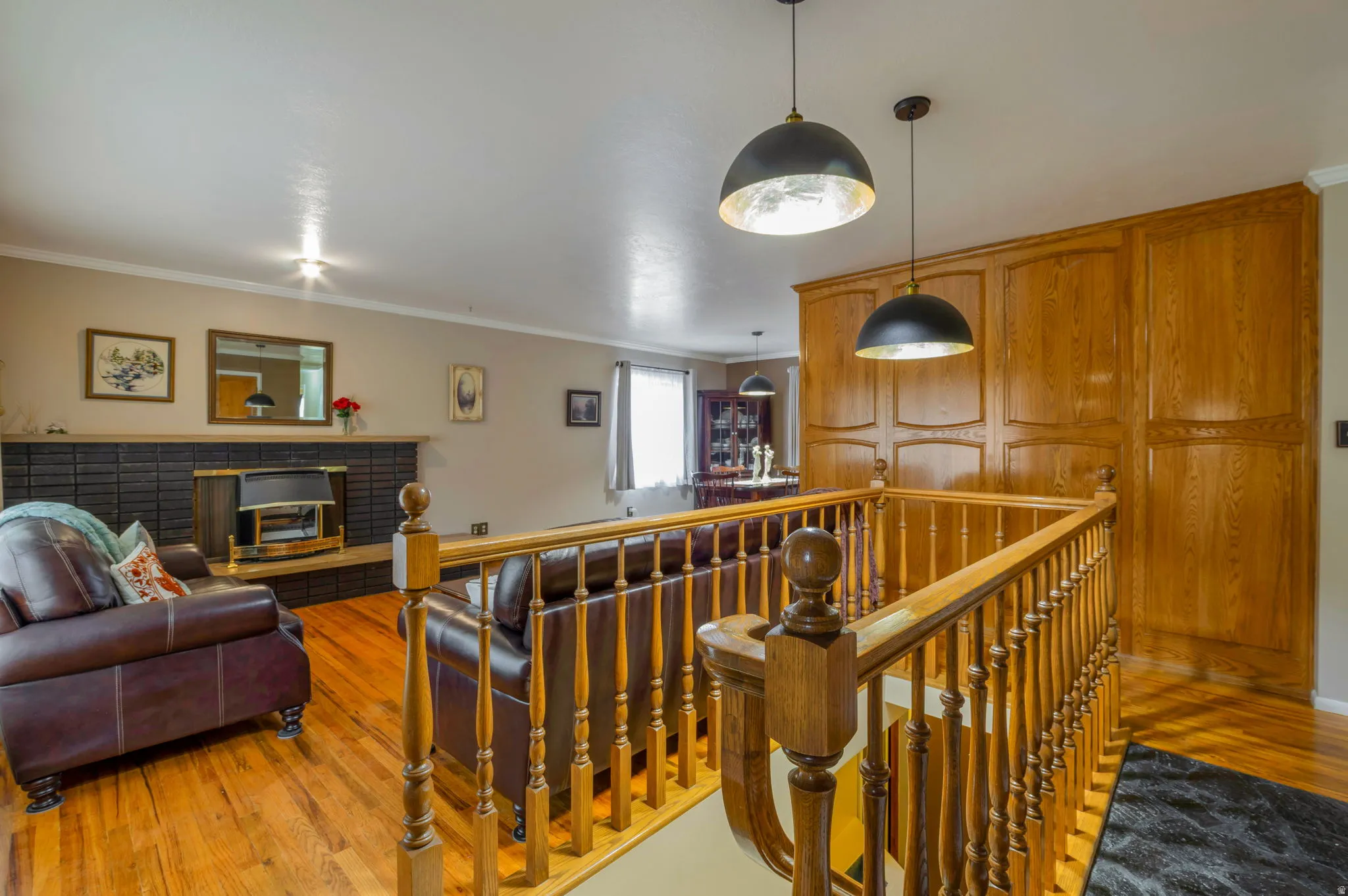 Hallway featuring an upstairs landing, light wood finished floors, and crown molding