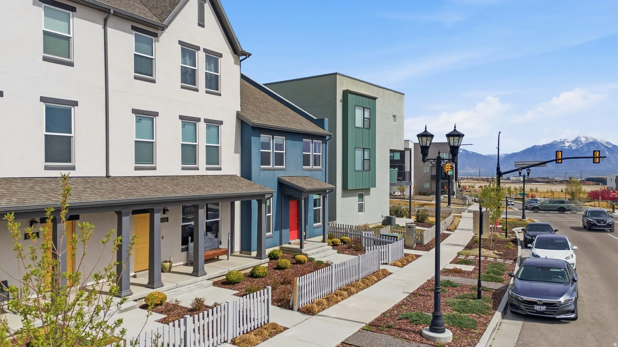 View of front of property featuring a shingled roof, stucco siding, a fenced front yard, and a mountain view