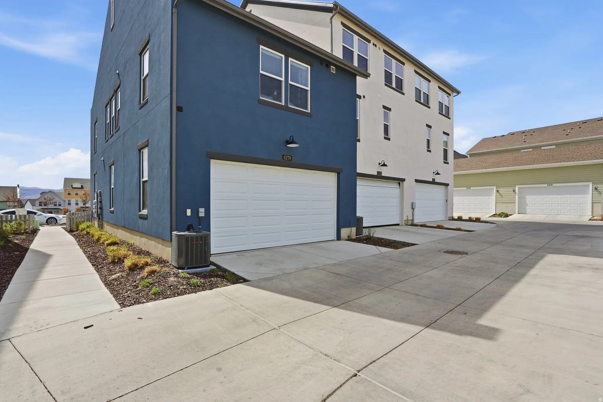 View of side of home featuring a garage, driveway, and stucco siding