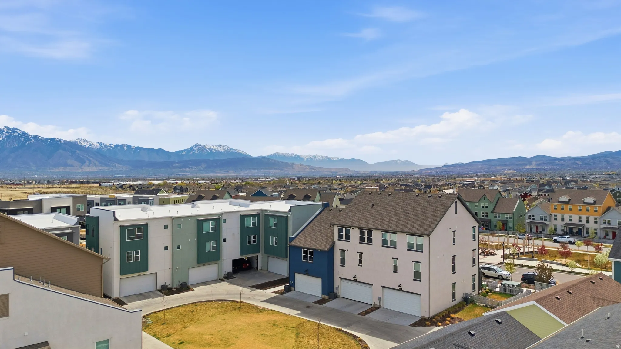 View of back of home featuring a garage, mountain view, and community backyard space