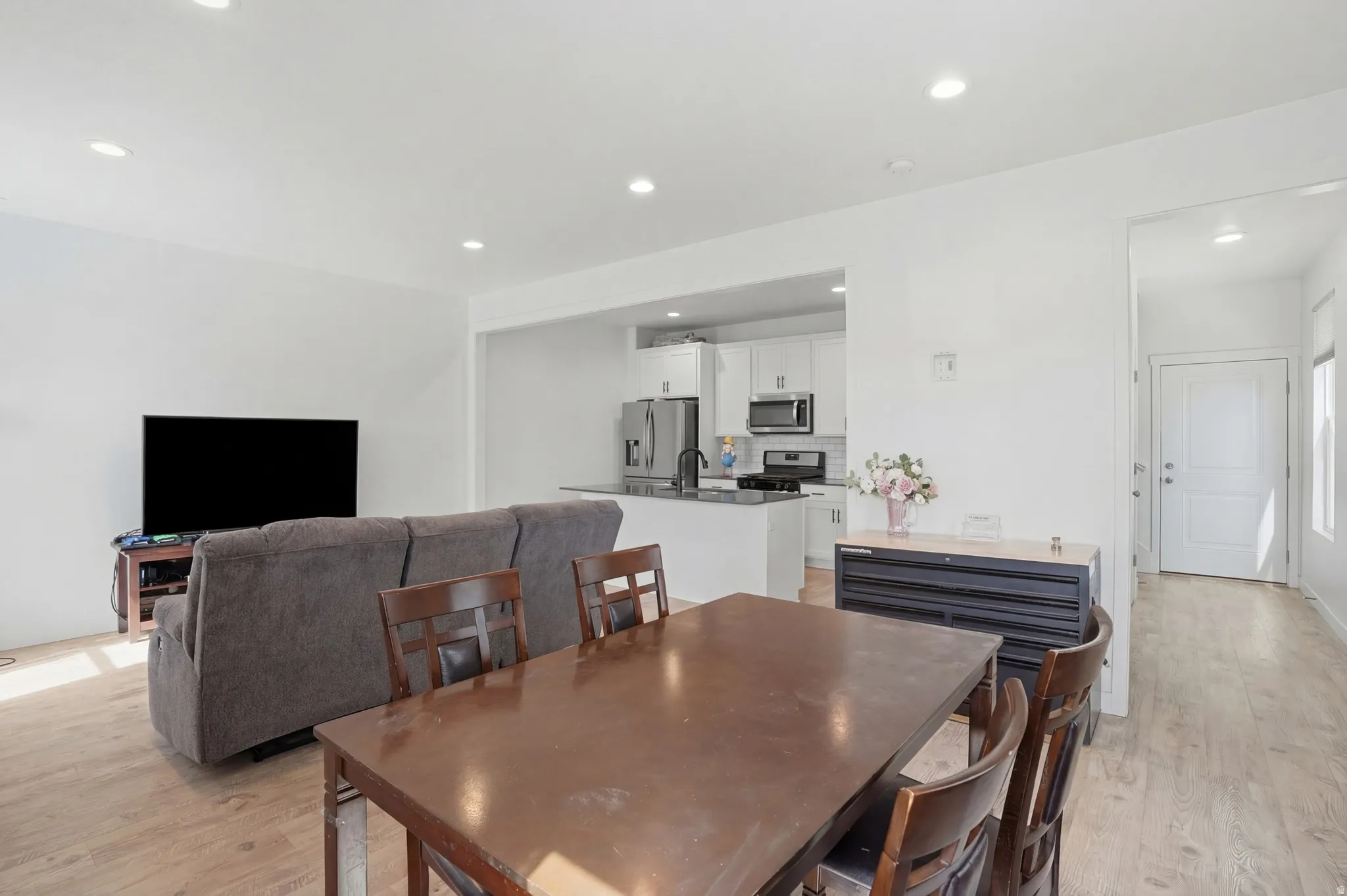 Dining area with light wood finished floors and recessed lighting