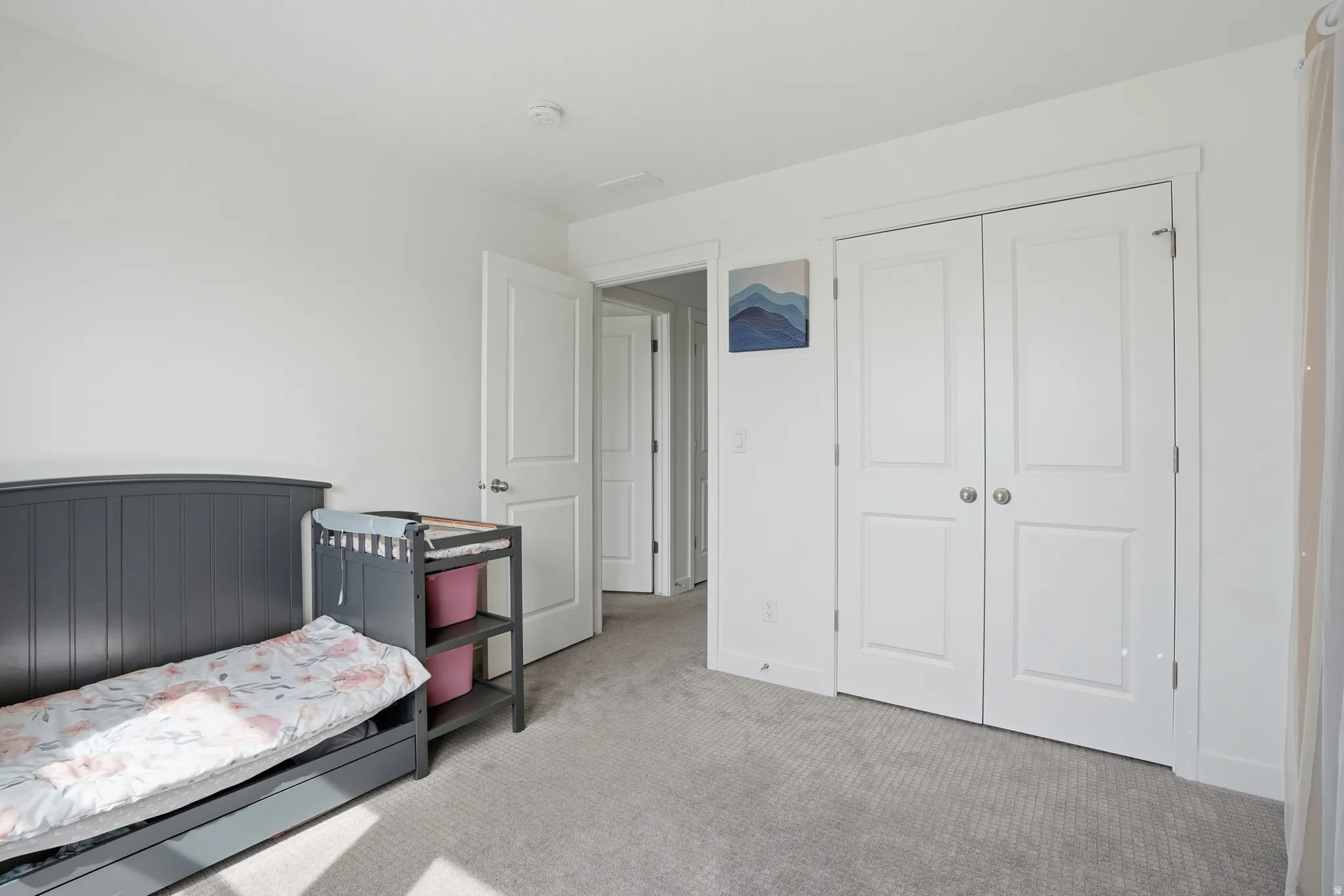 Second bedroom featuring light carpet and a closet