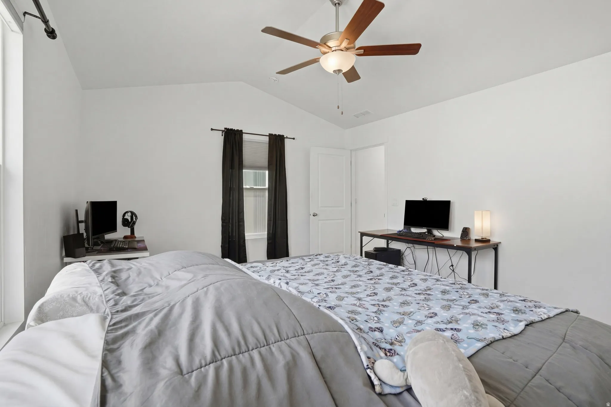 Primary bedroom with lofted ceiling and ceiling fan