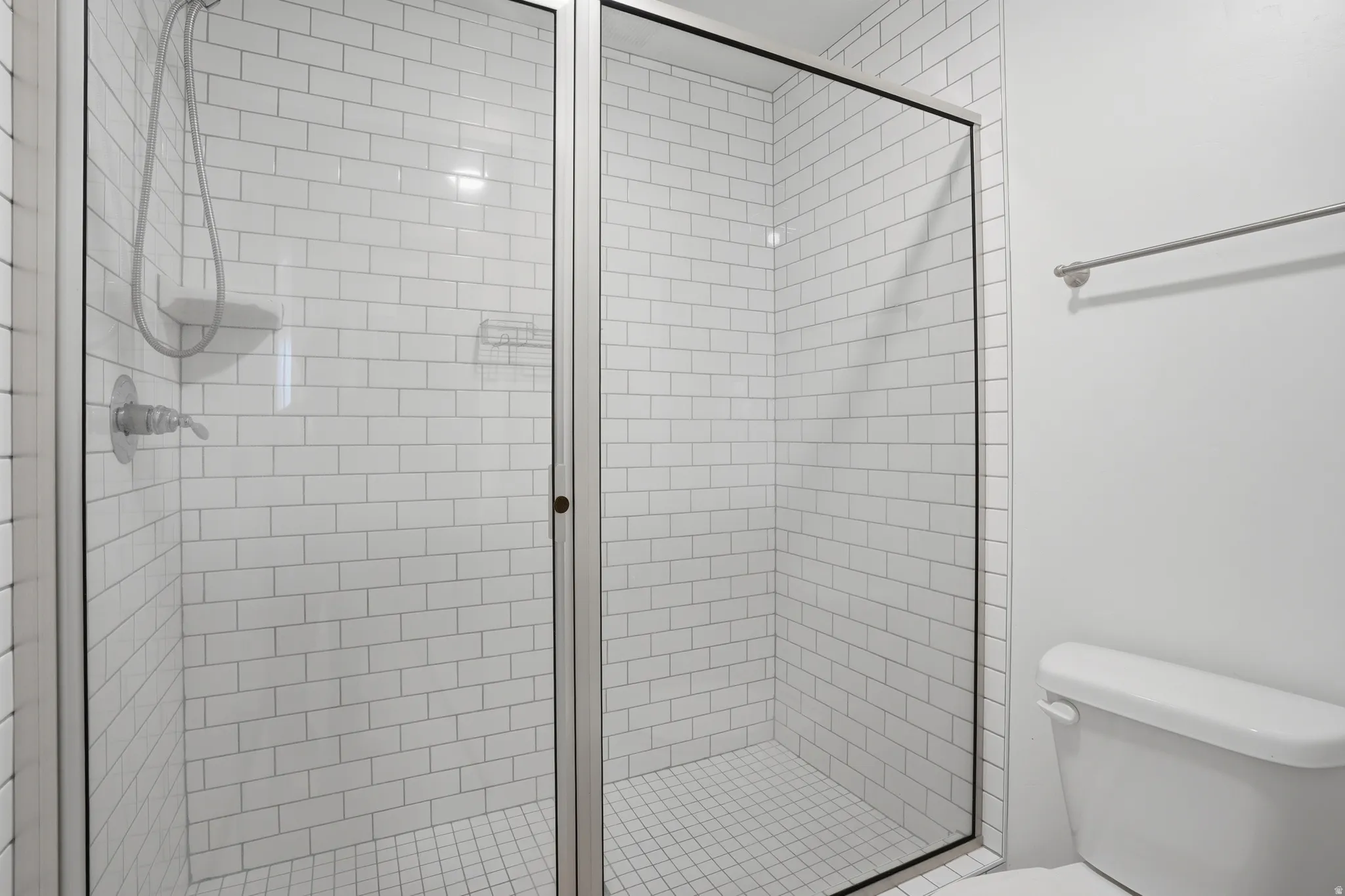 Full bath featuring toilet and oversized tile shower