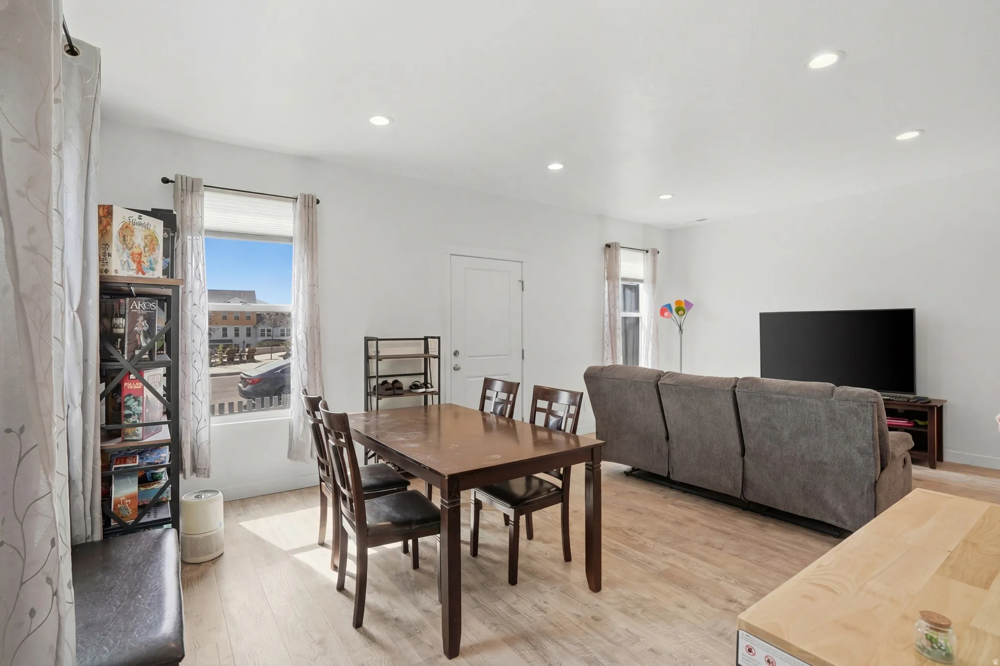 Dining room with light wood-style floors and recessed lighting