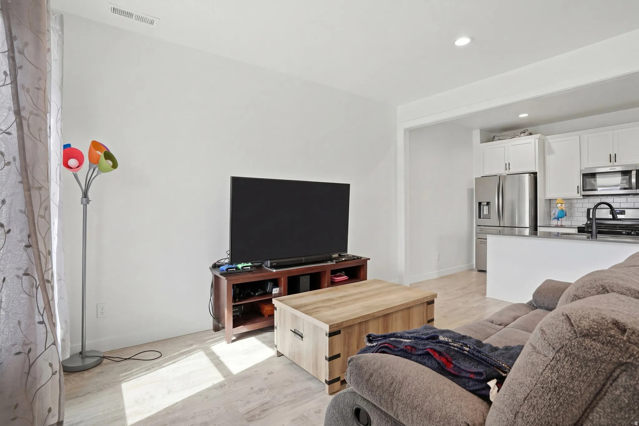 Living room featuring light wood finished floors and recessed lighting