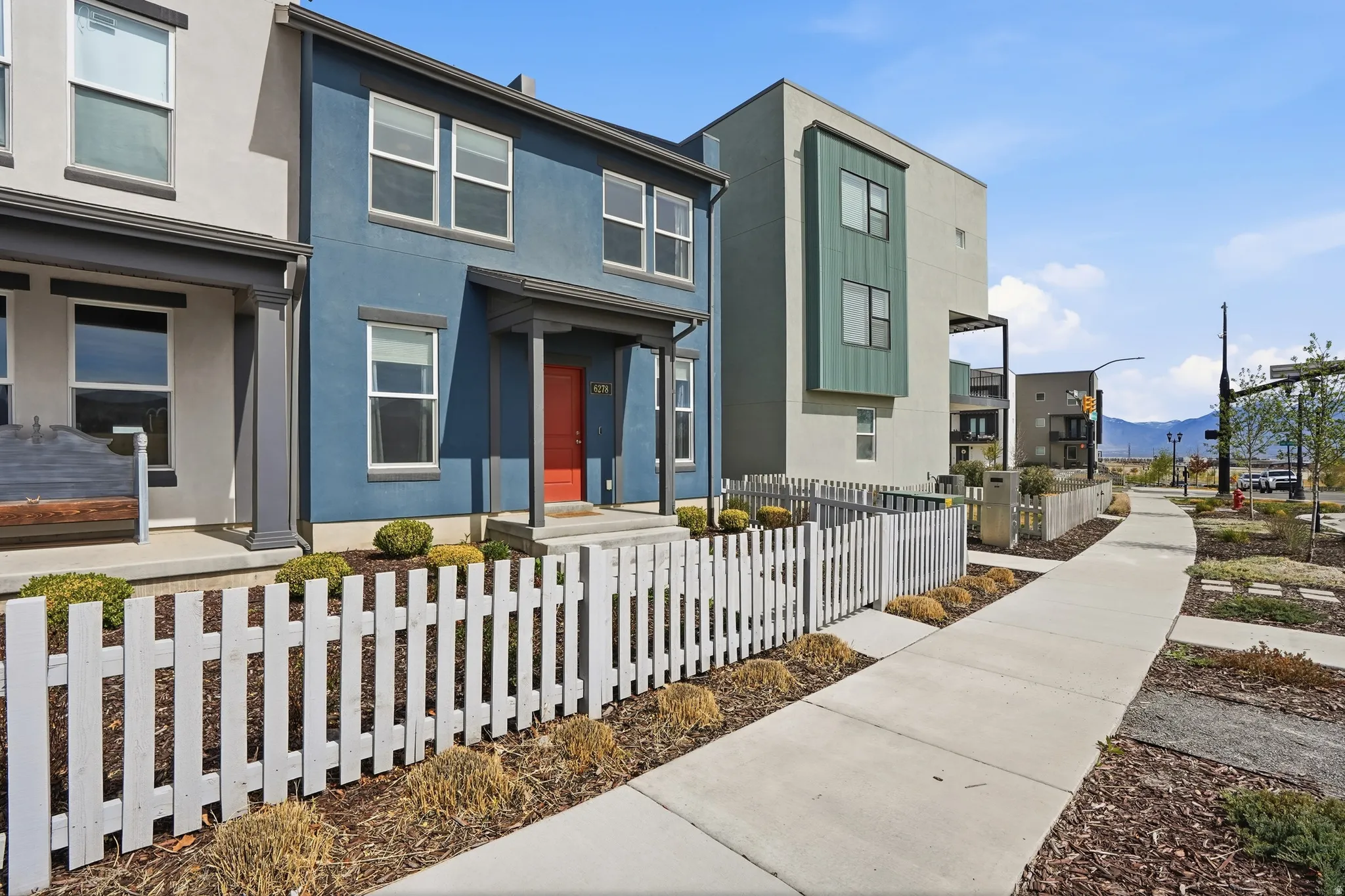 Modern home featuring a fenced front yard, stucco siding, and a mountain view