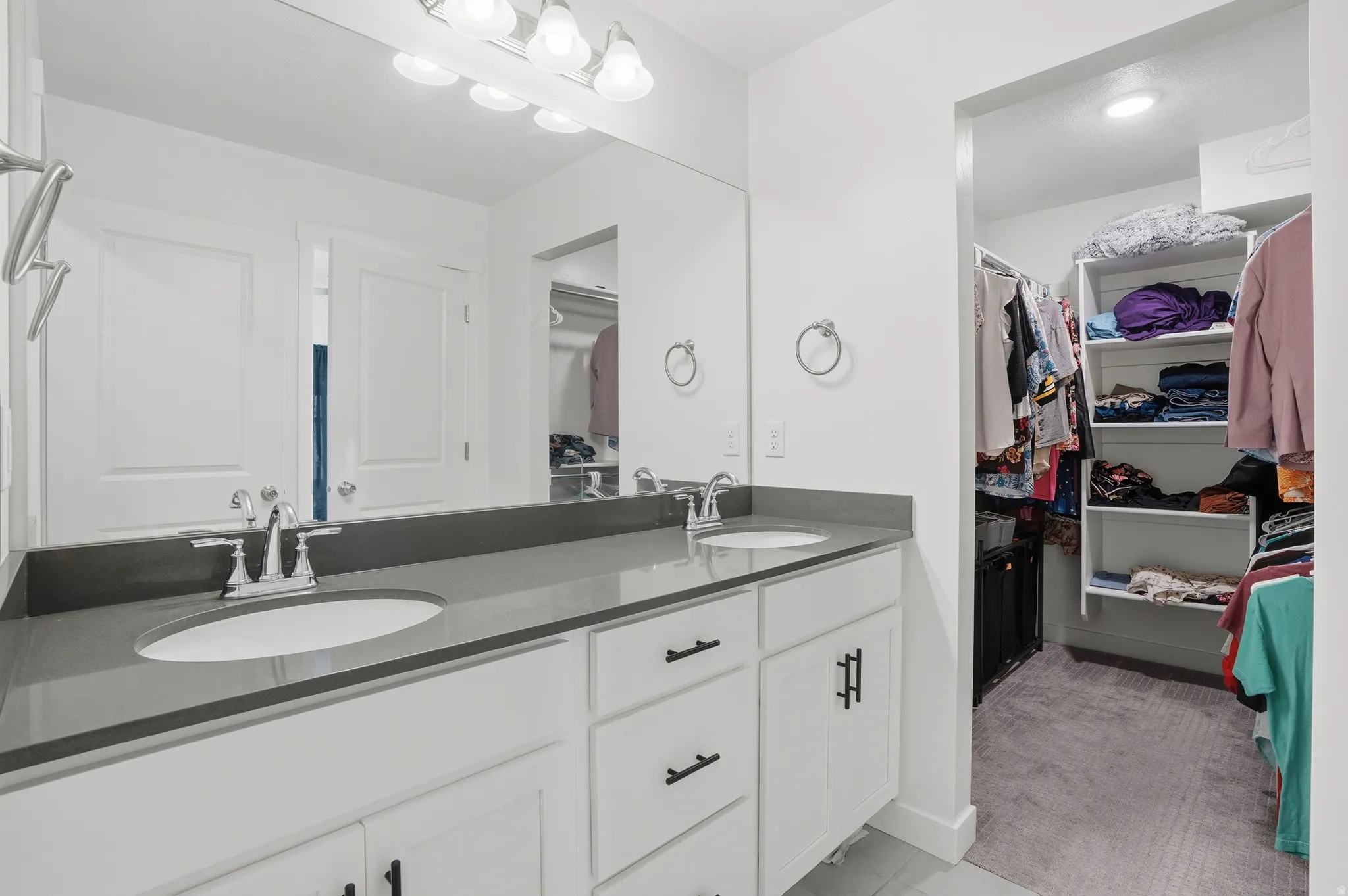 En suite bathroom with double vanity and a walk-in closet