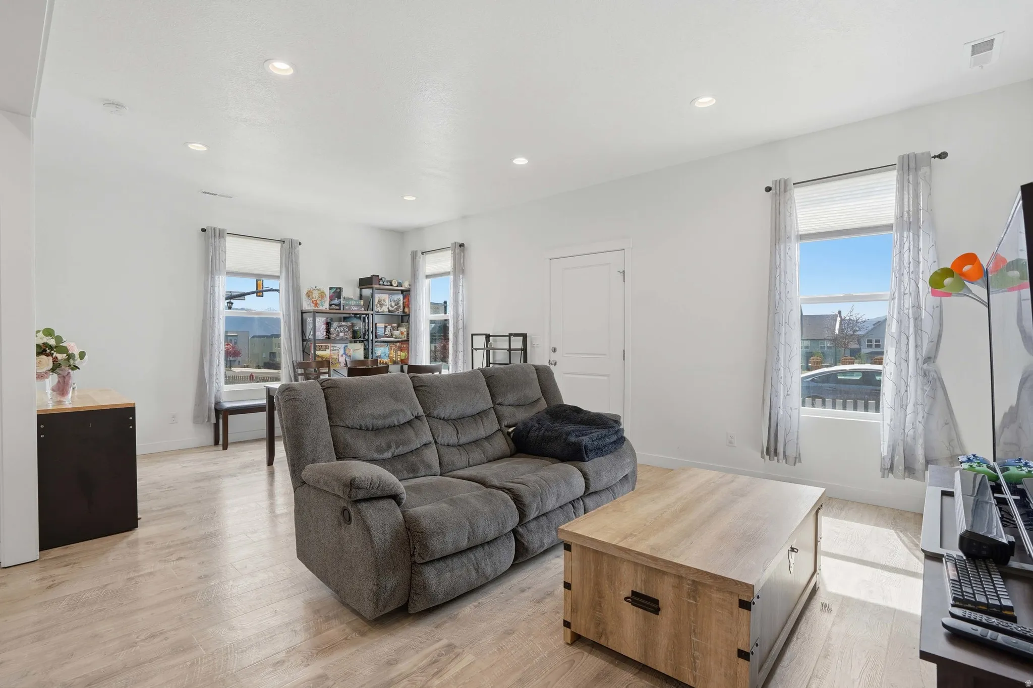Living area with light wood-type flooring, plenty of natural light, and recessed lighting