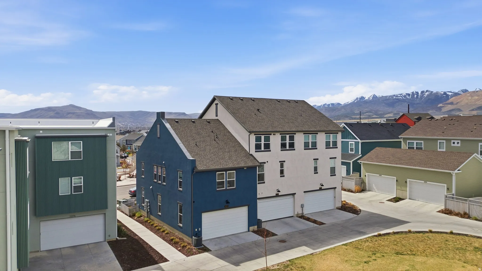 View of back of home featuring a garage, mountain view, and community backyard space