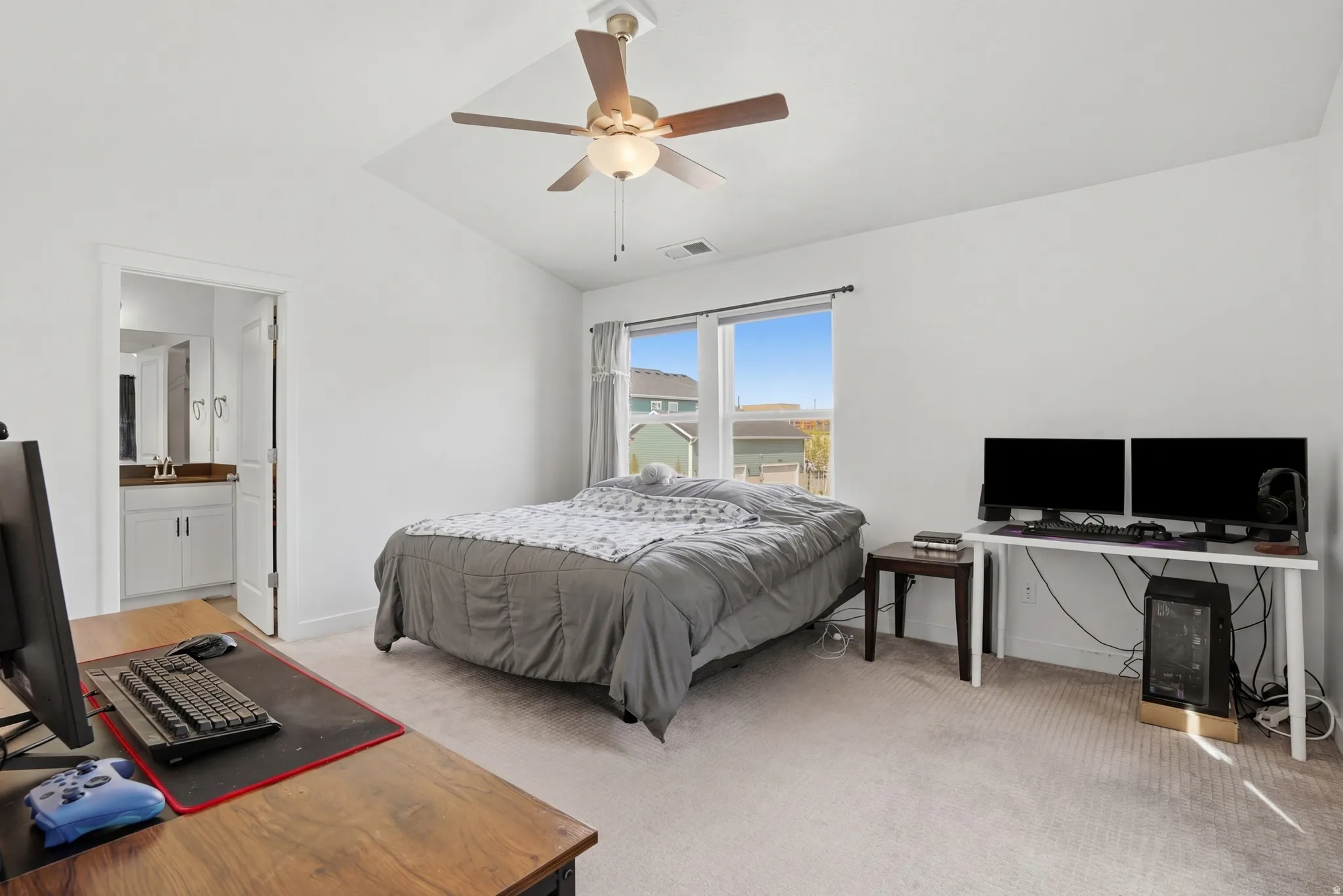 Primary bedroom featuring lofted ceiling, an office area, and connected bathroom
