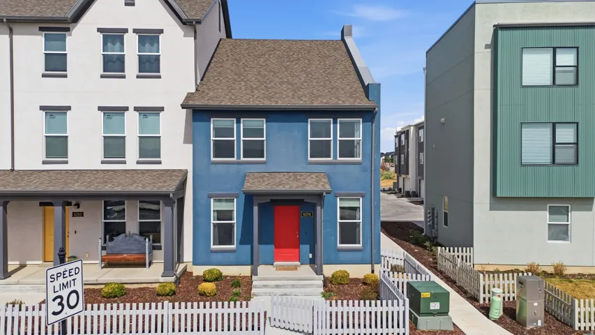 View of front of house featuring a shingled roof, stucco siding, and a fenced front yard