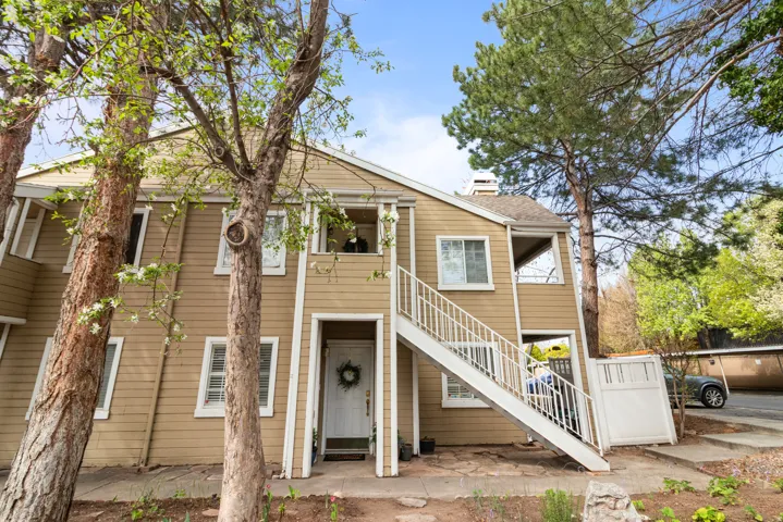View of front of home featuring a chimney and a balcony