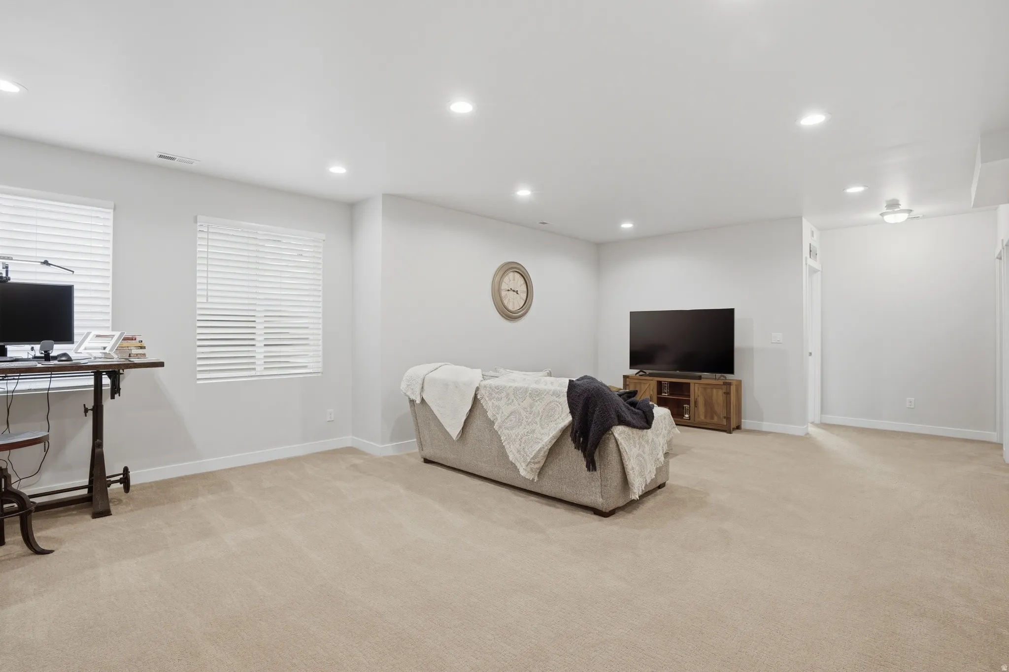 Living area with recessed lighting, light colored carpet, and an office area
