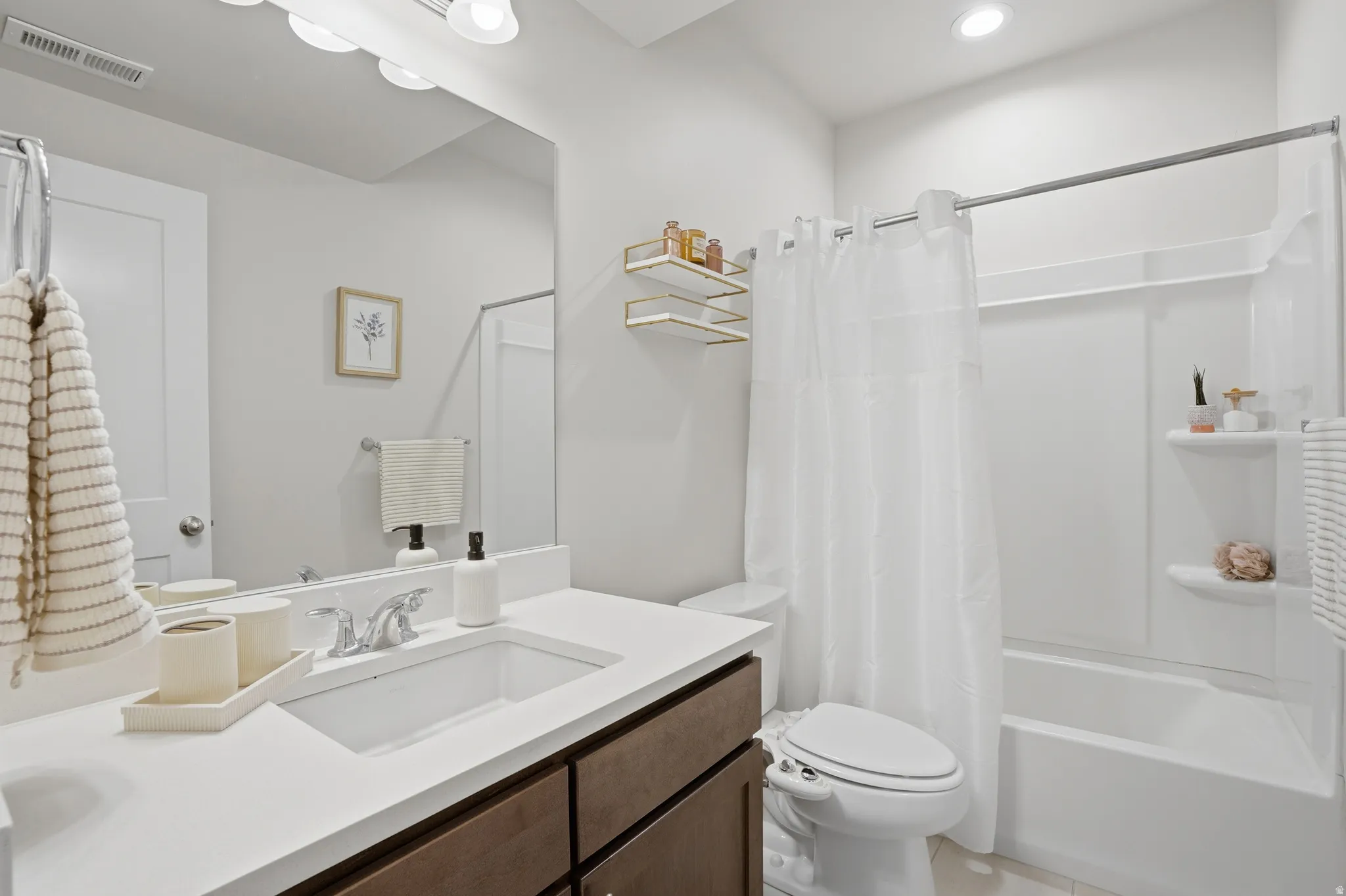 Bathroom with vanity, shower / bath combo, and light tile patterned floors