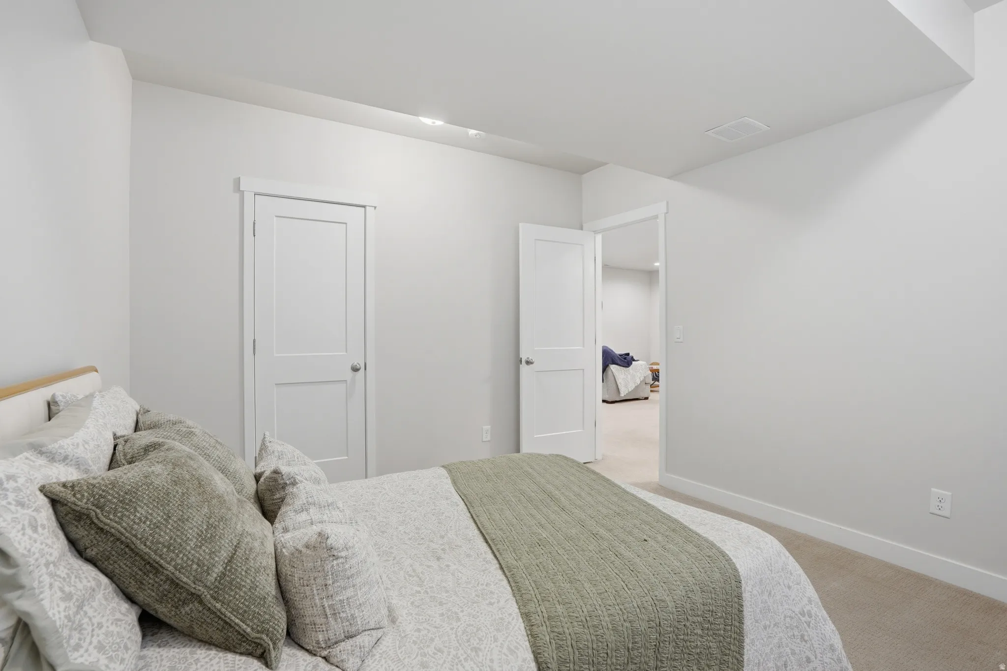 Bedroom featuring light carpet and baseboards