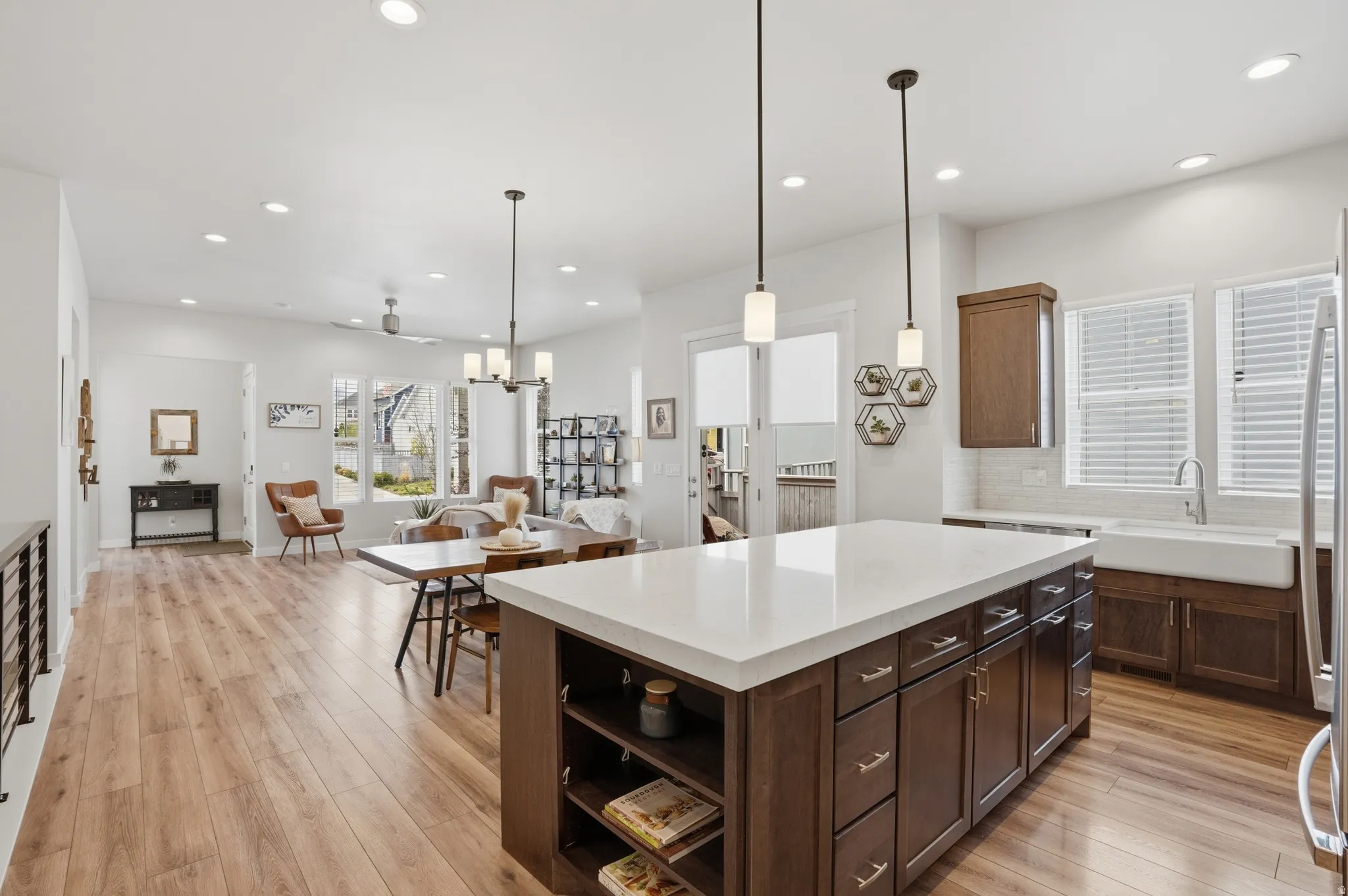 Kitchen with a center island, backsplash, open shelves, open floor plan, and light wood-type flooring