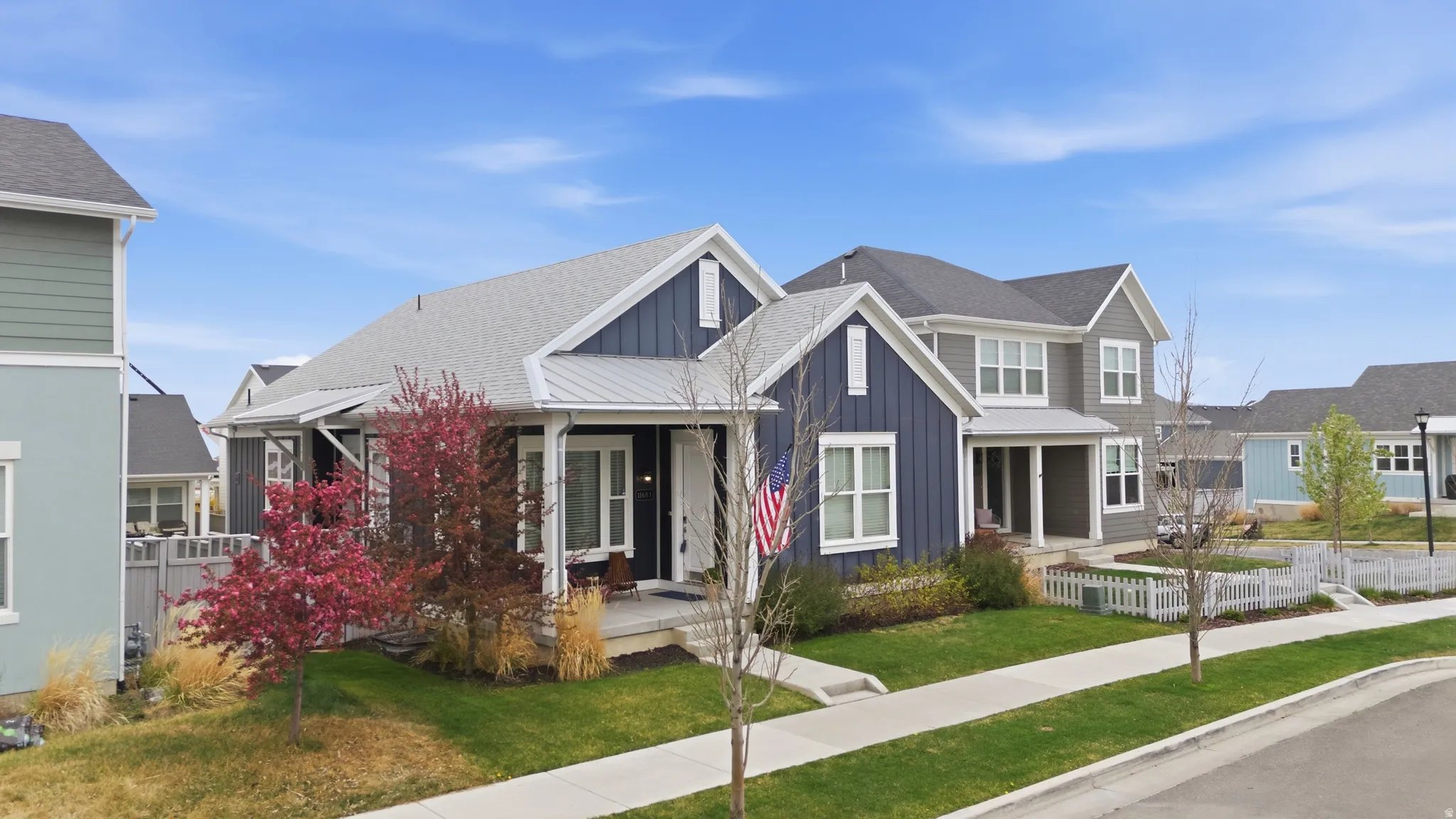 View of front facade featuring board and batten siding, roof with shingles, and covered porch