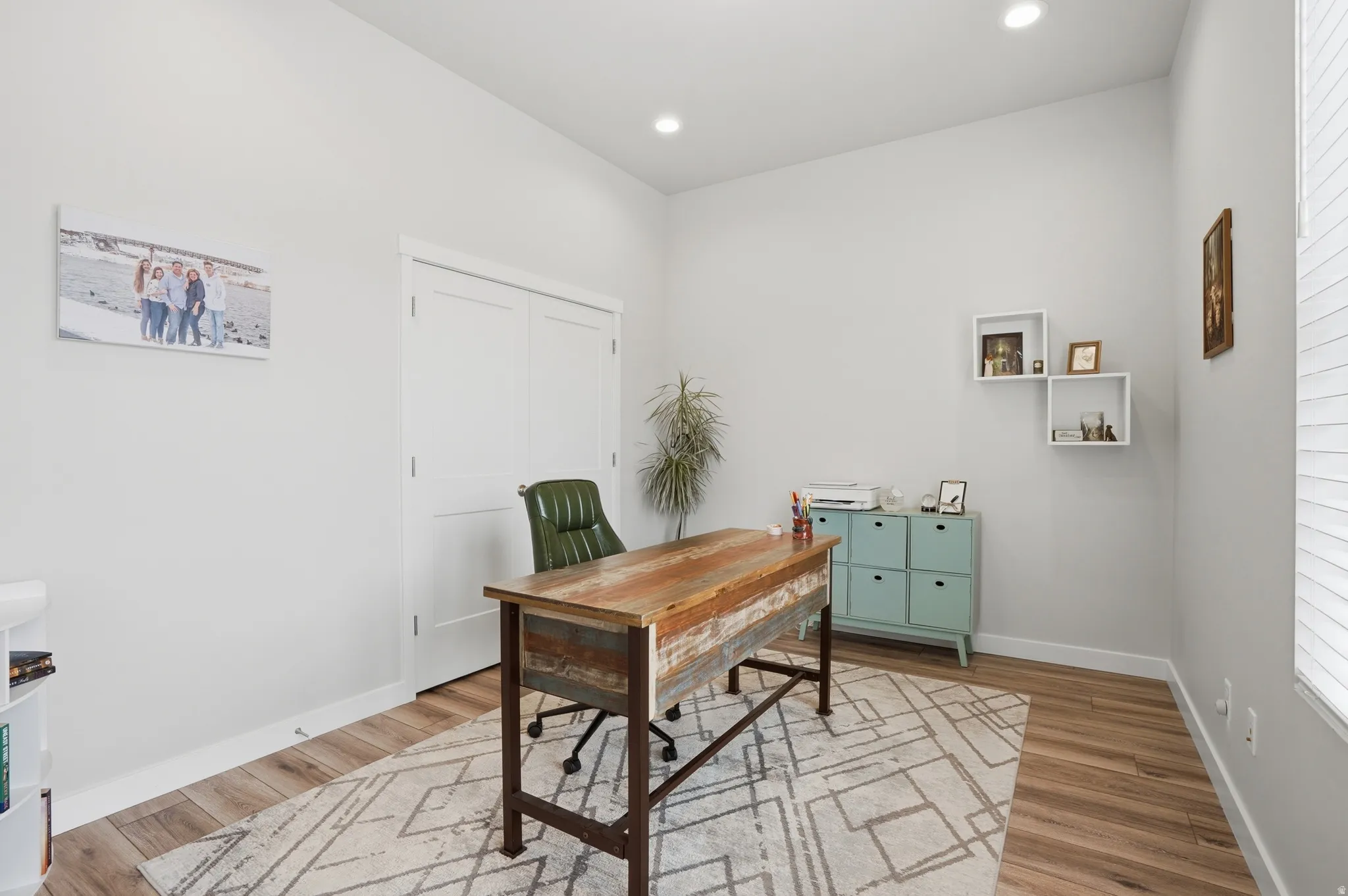 Office space with light wood-style floors and recessed lighting