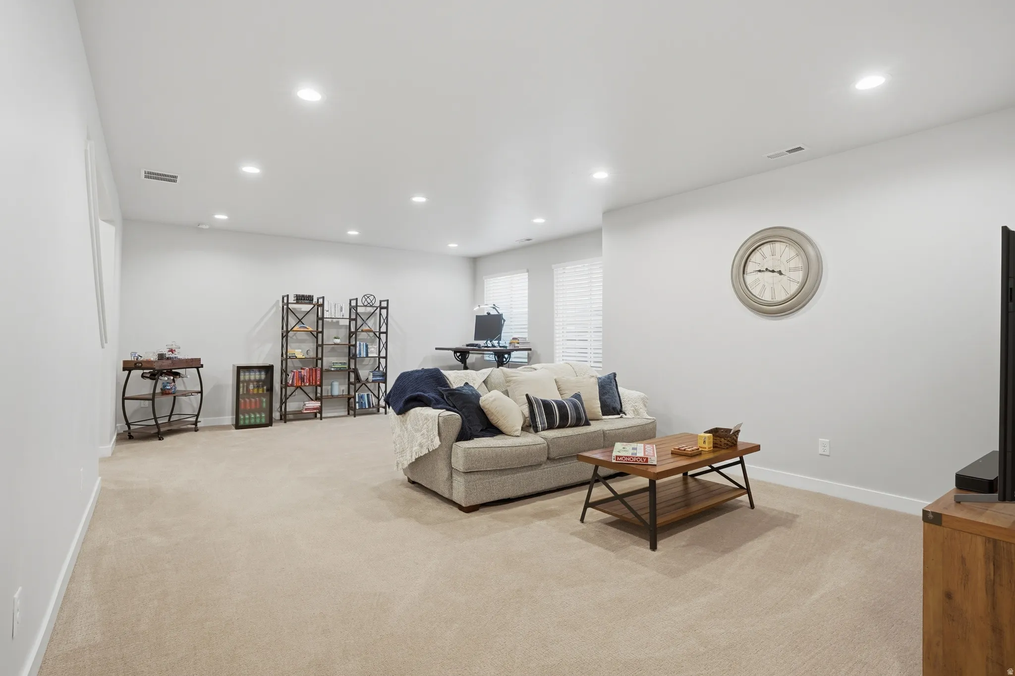 Living area featuring light colored carpet and recessed lighting