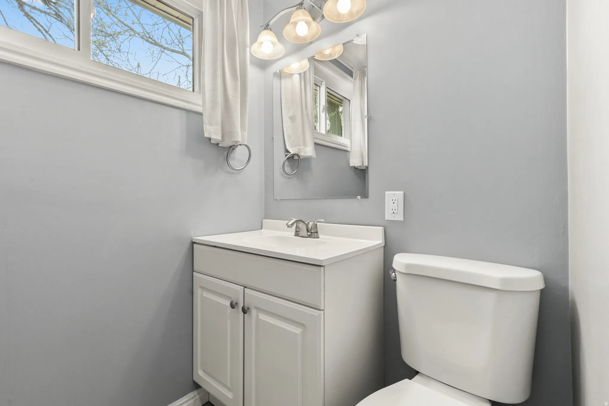 Half bathroom with healthy amount of natural light and vanity