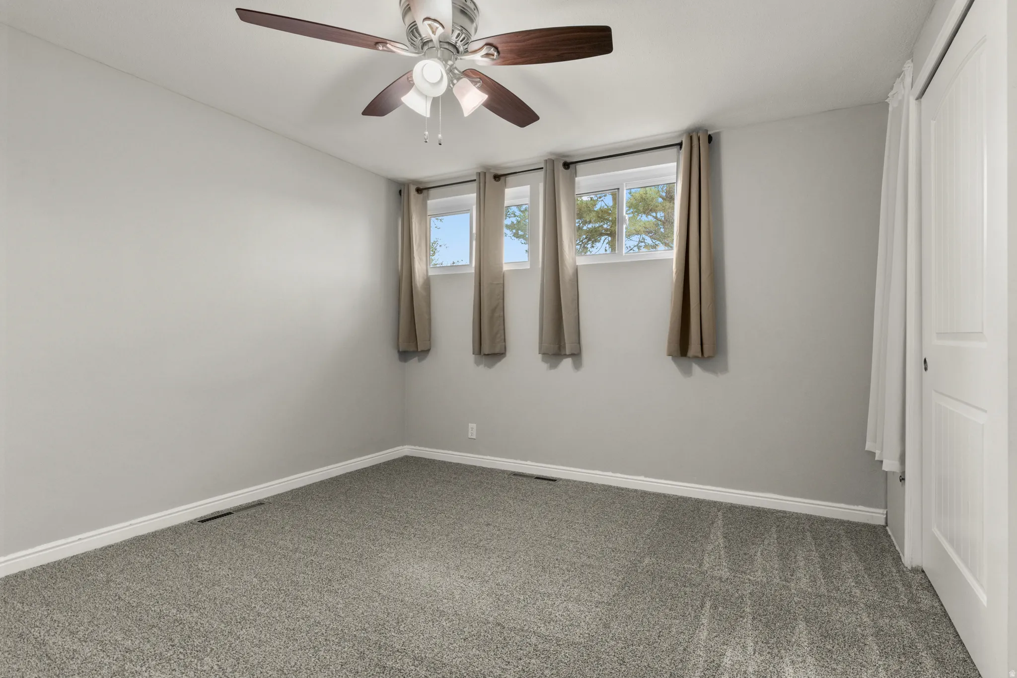 Spare room featuring carpet flooring and a ceiling fan