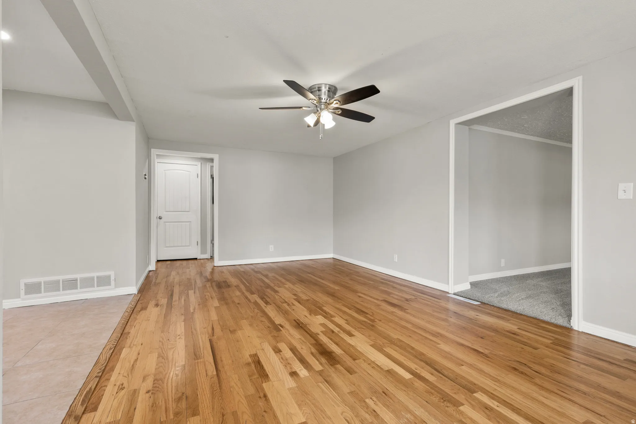 Empty room featuring a ceiling fan and light wood-style floors