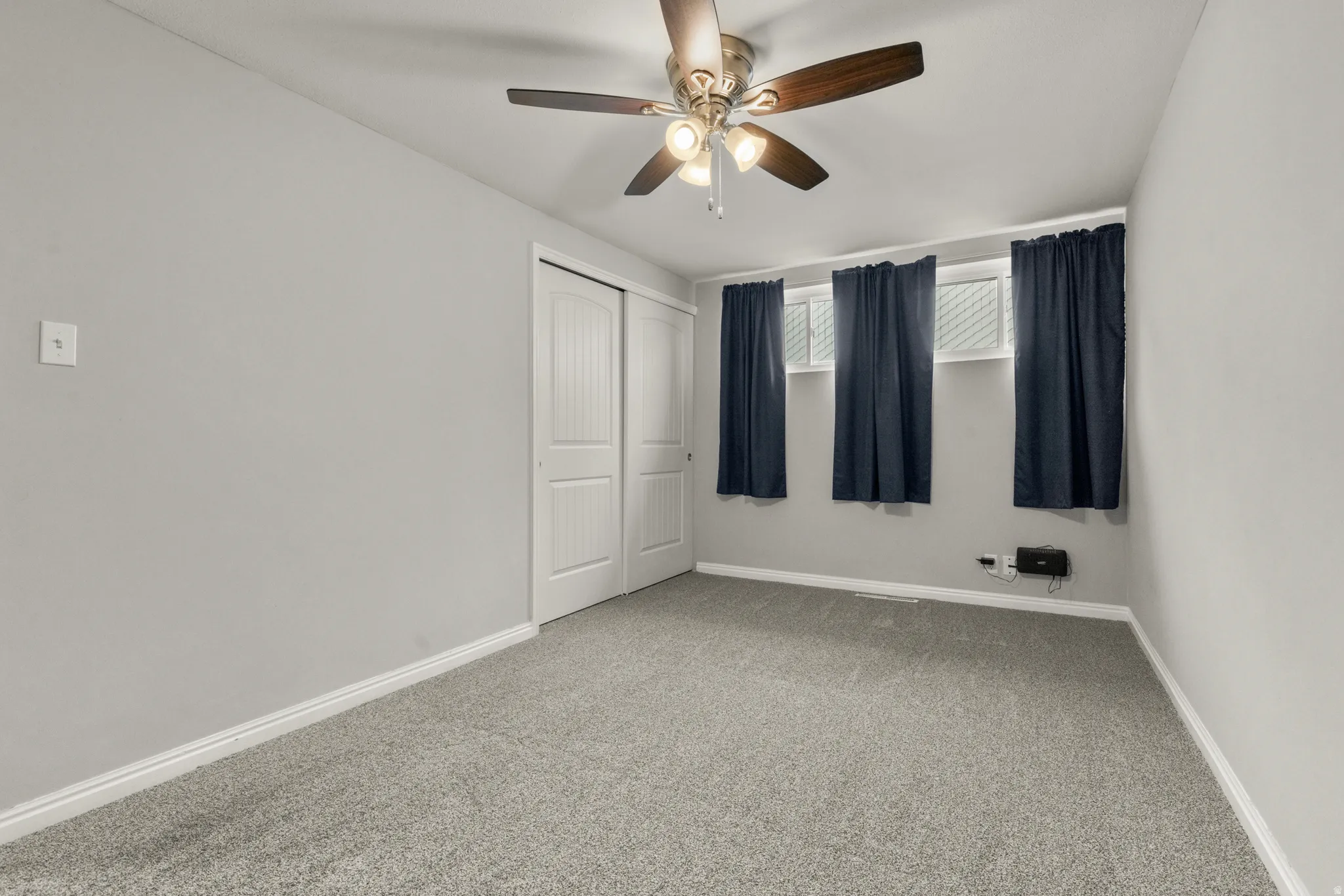 Unfurnished bedroom with carpet floors, a closet, and a ceiling fan