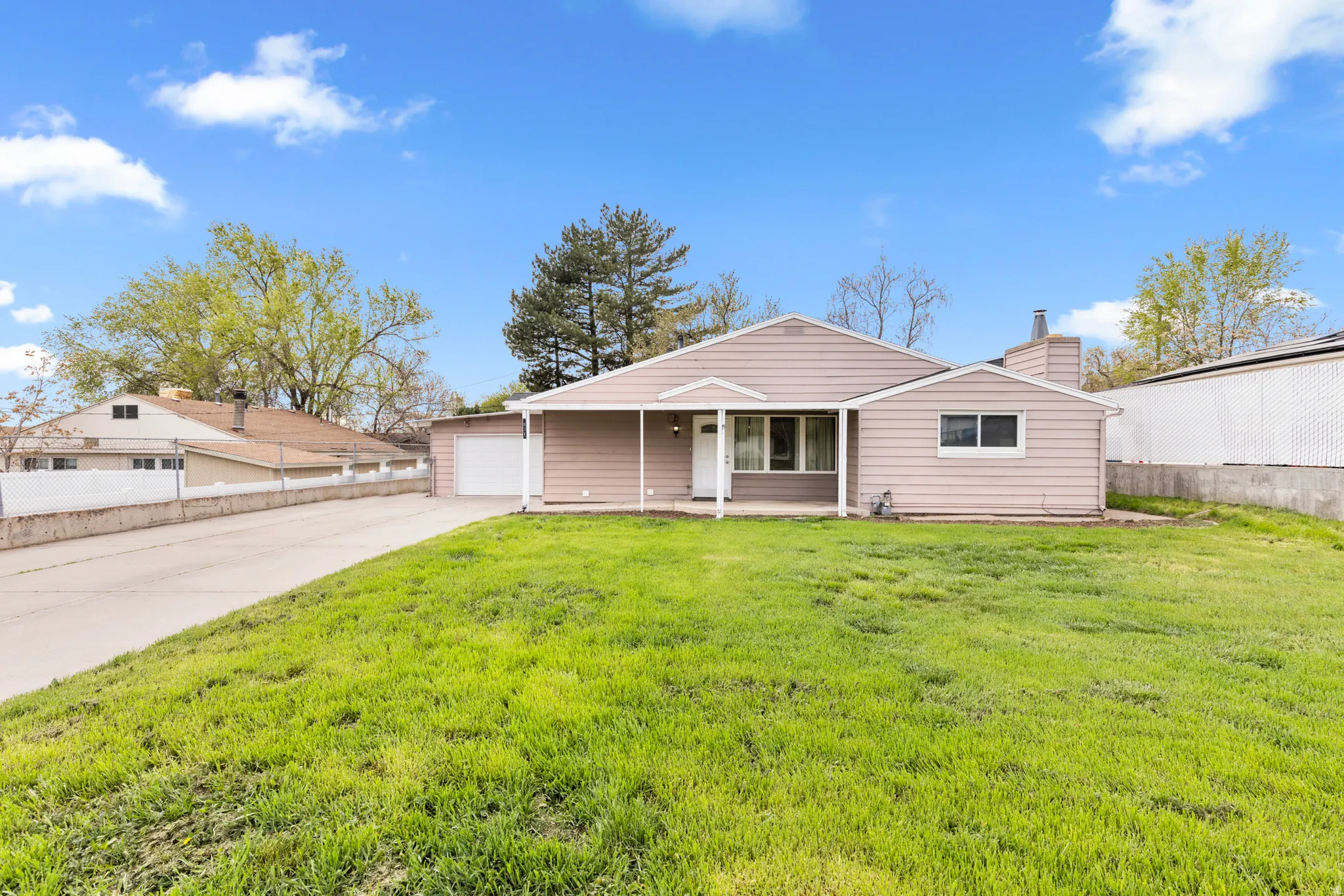 View of front of home with a garage, a chimney, a patio, and driveway