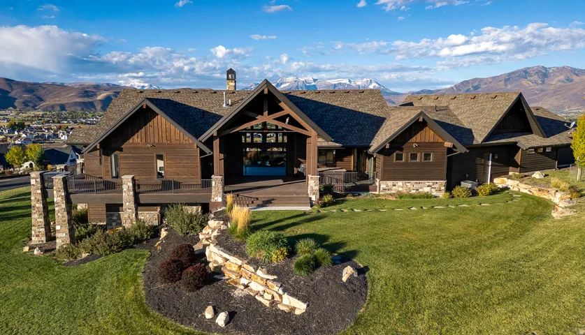 View of front of home with a mountain view, stone siding, a front yard, and board and batten siding