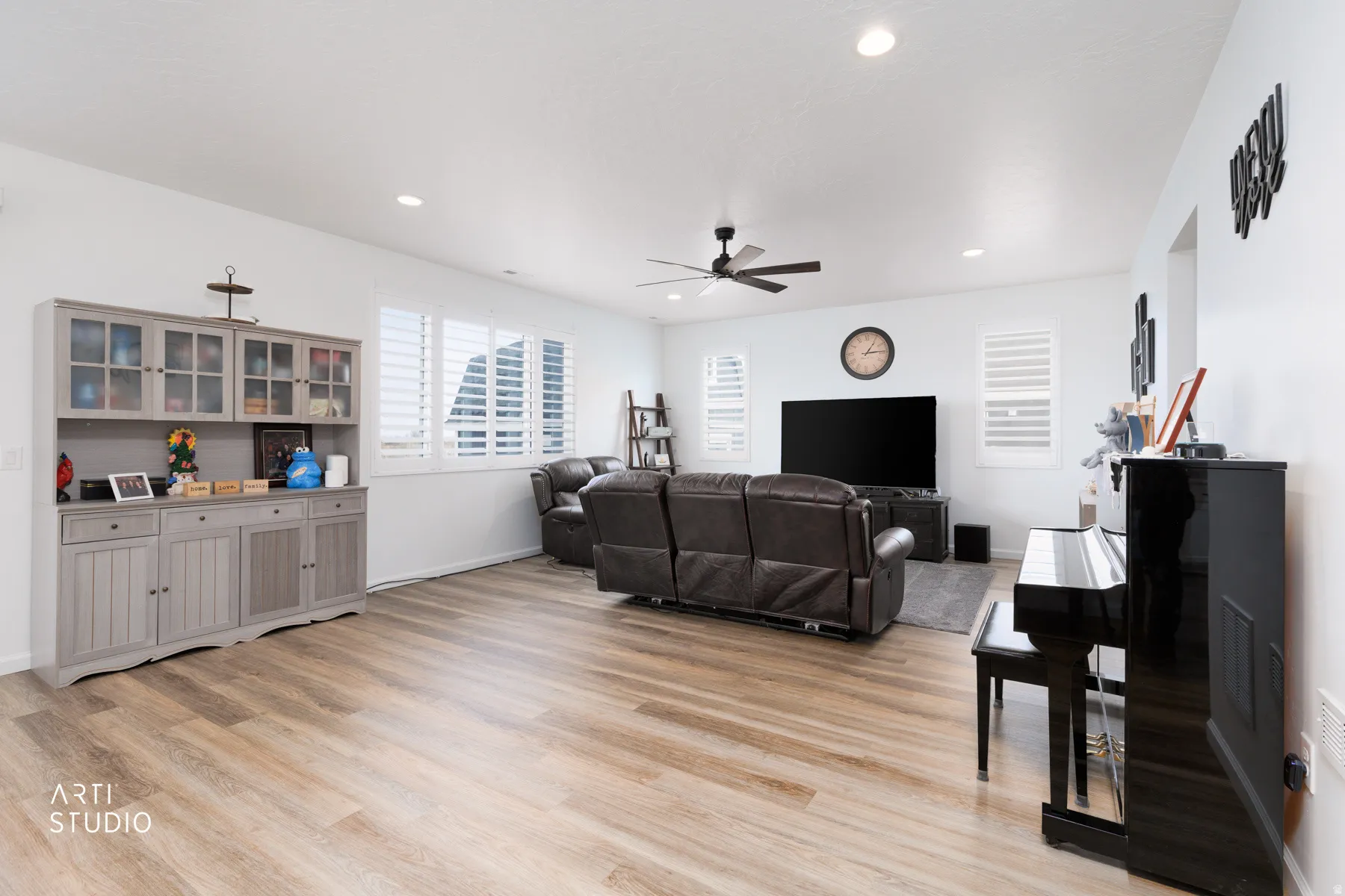 Living area featuring light wood-style flooring, a ceiling fan, and recessed lighting