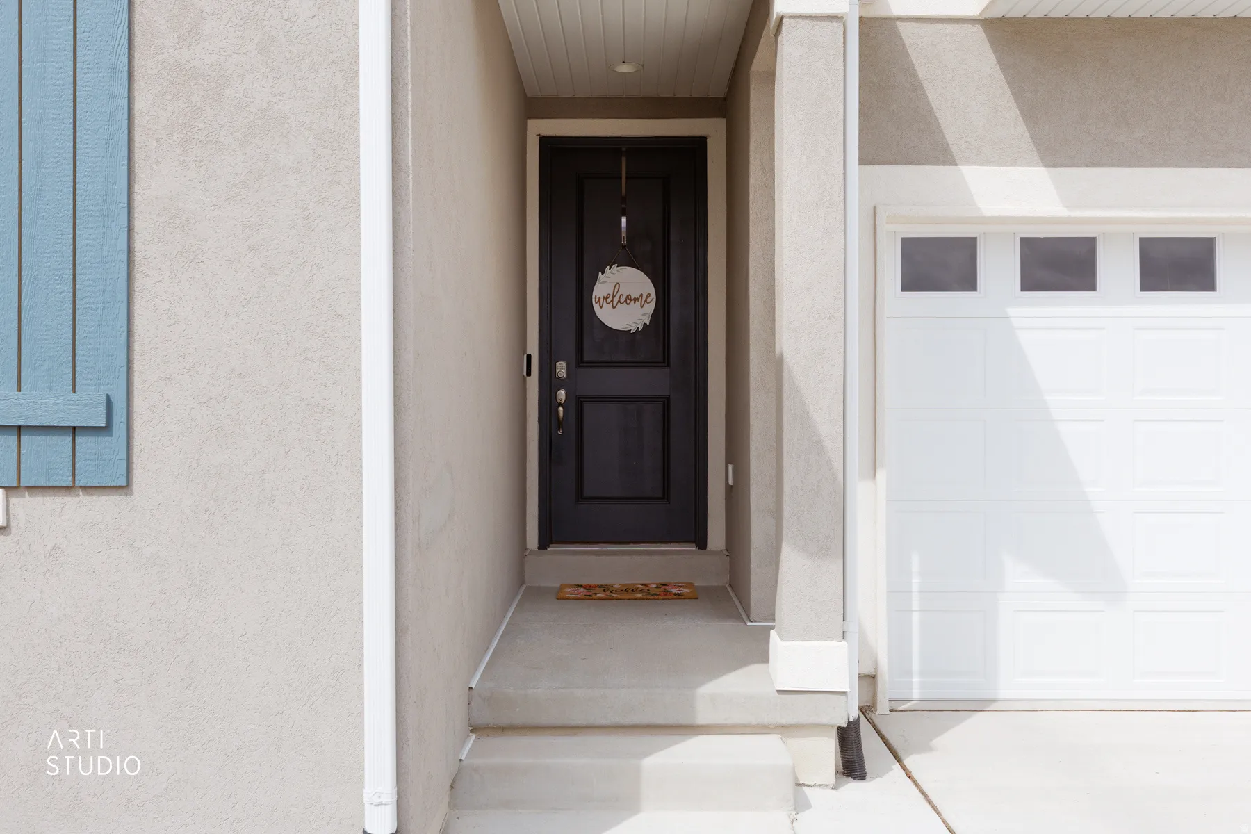 Doorway to property with a garage and stucco siding
