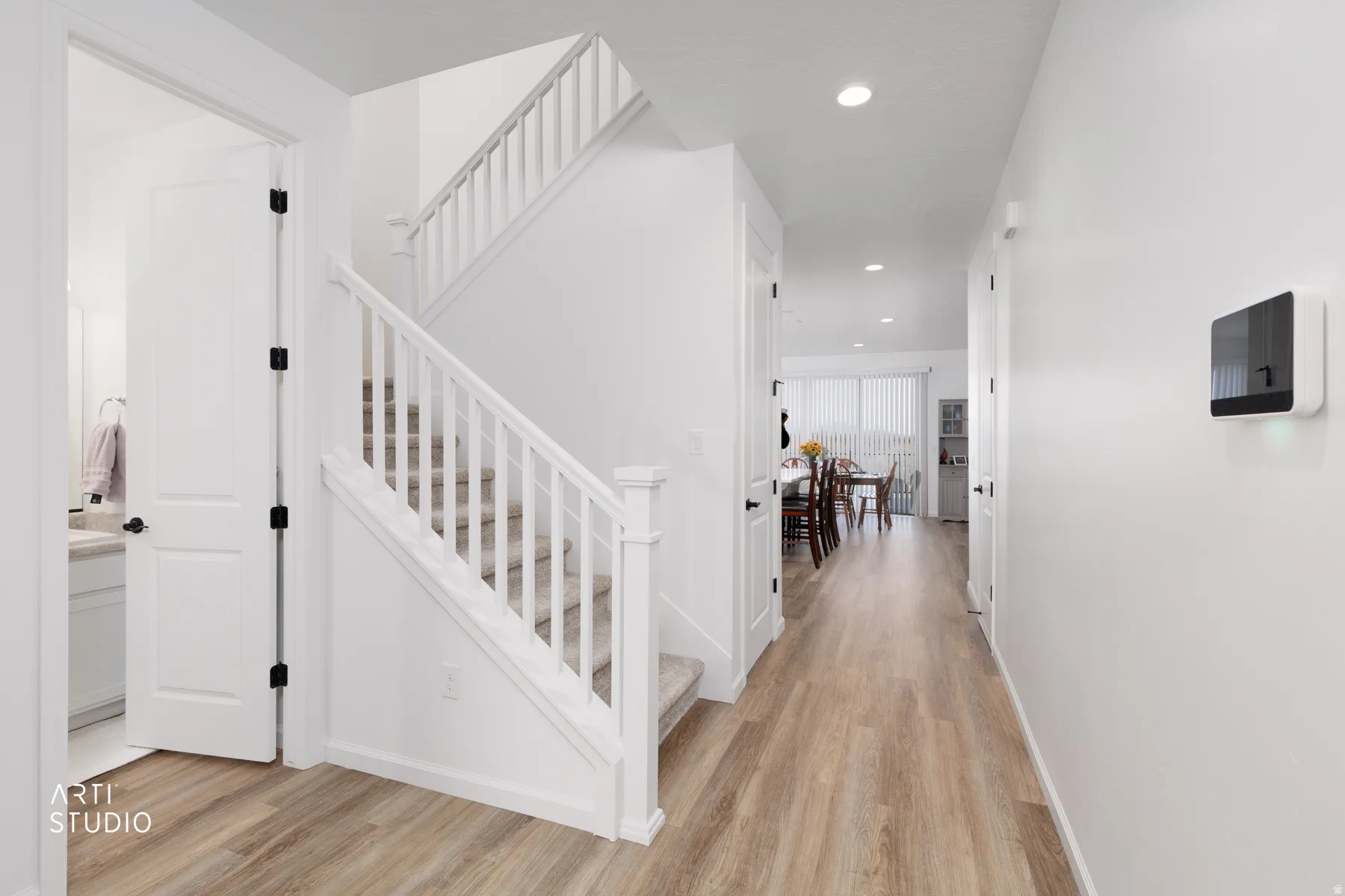 Stairs with wood finished floors and recessed lighting