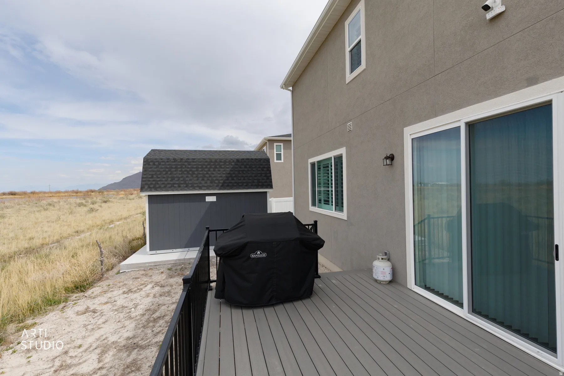 Wooden deck with area for grilling, a storage unit, and a mountain view