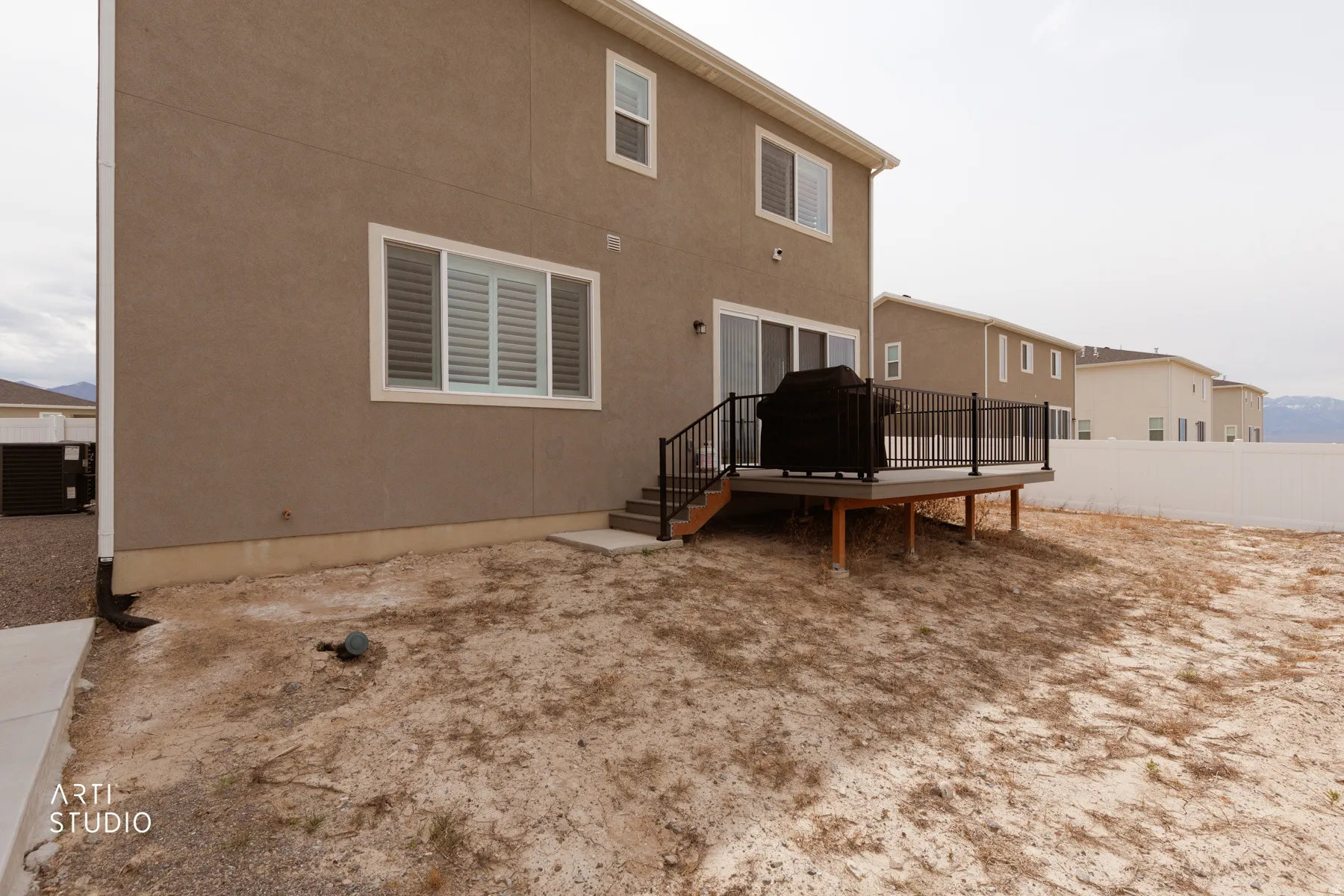 Rear view of house featuring a deck and stucco siding