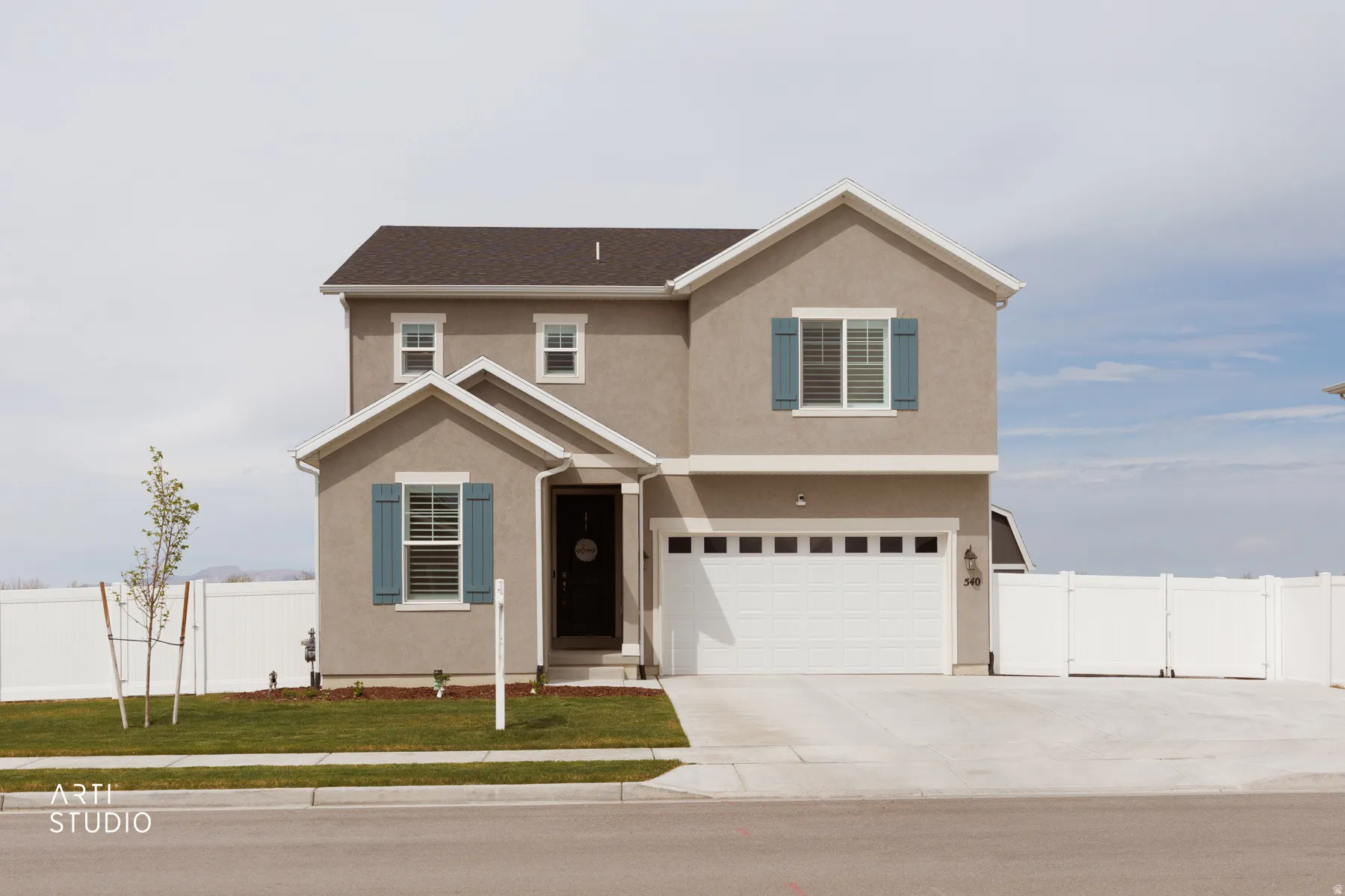 Traditional-style house featuring stucco siding, a garage, and concrete driveway
