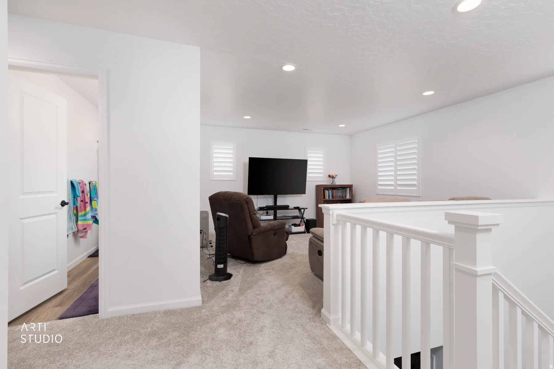 Hallway featuring an upstairs landing, light colored carpet, and recessed lighting