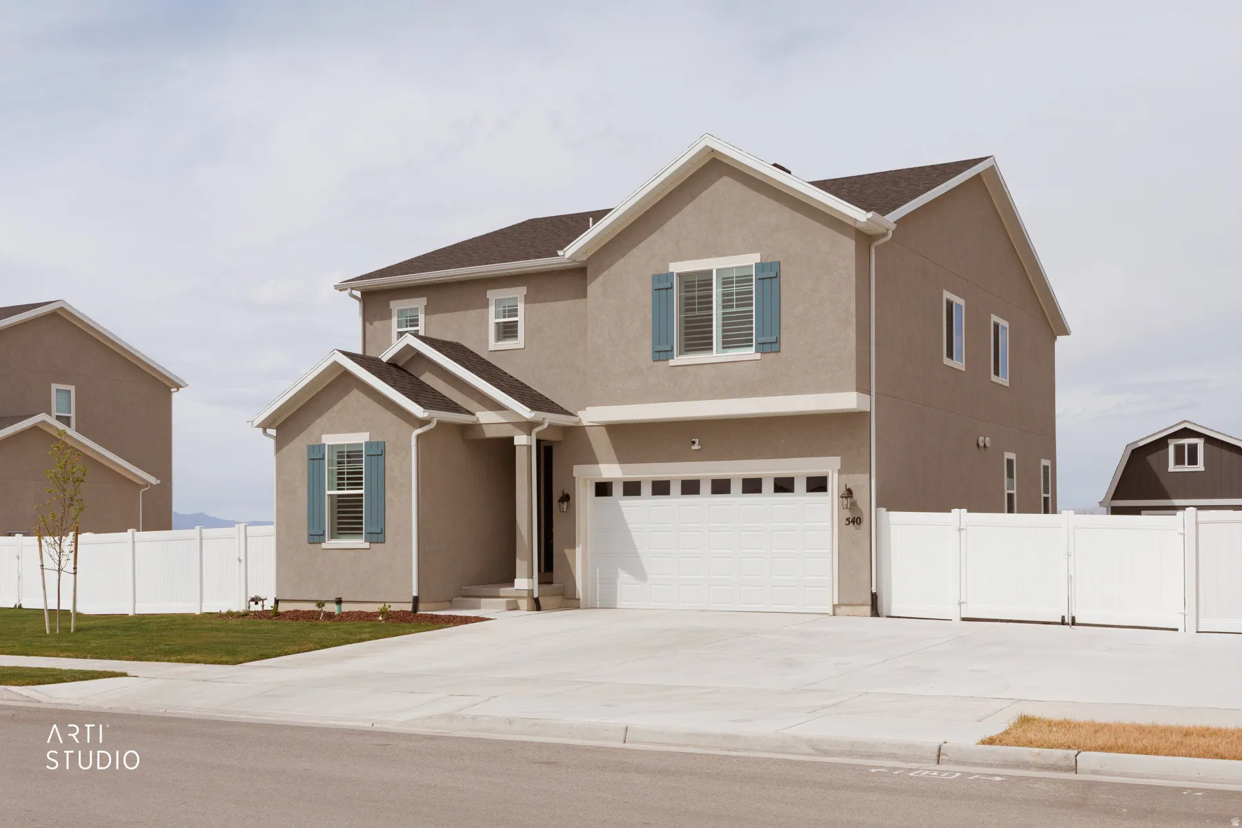 Traditional-style house with an attached garage, stucco siding, and driveway