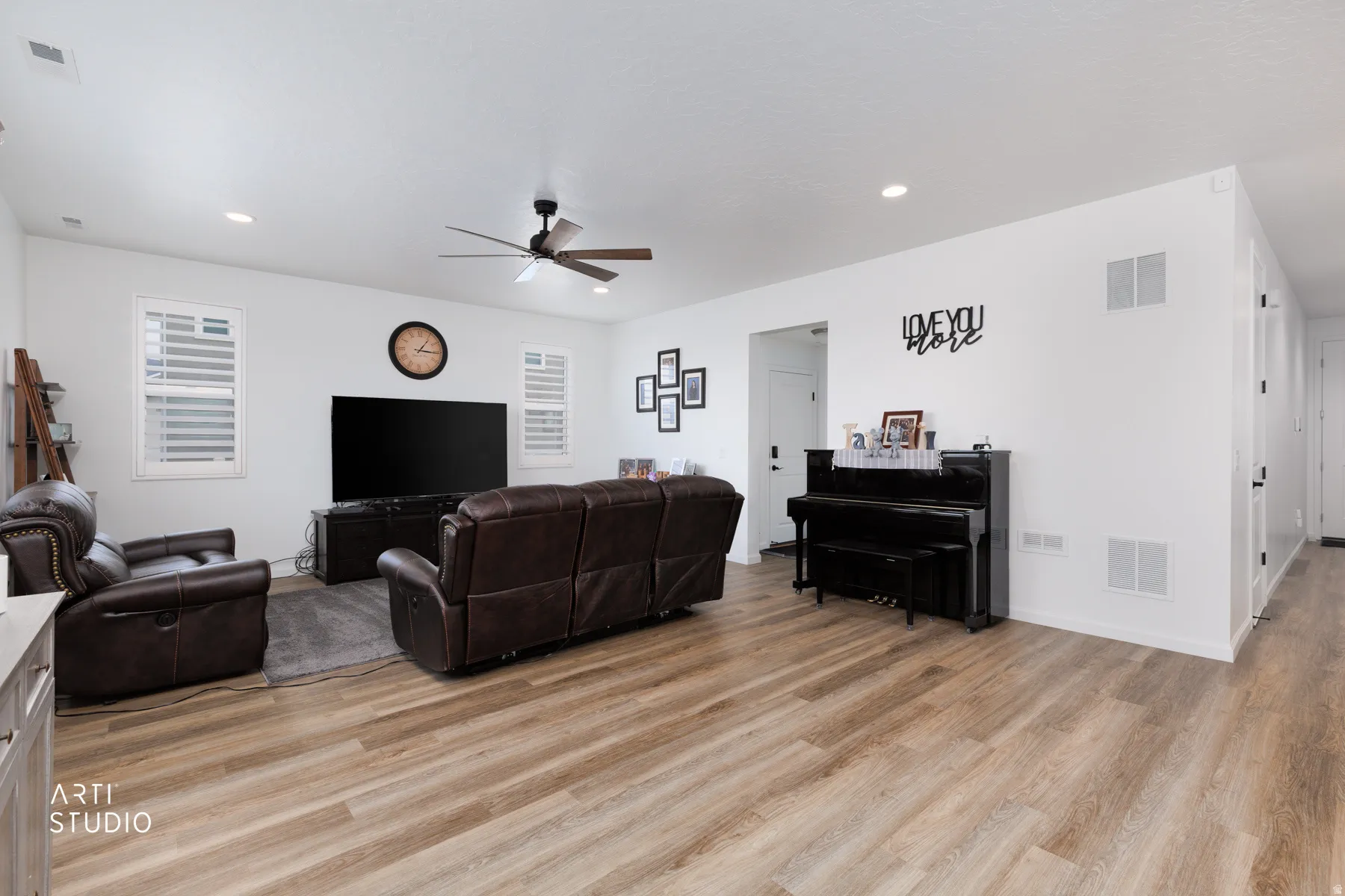Living room featuring light wood-type flooring, a ceiling fan, and recessed lighting