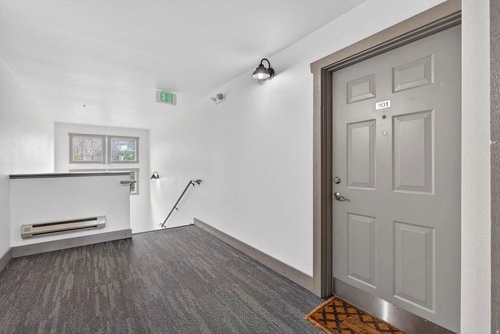 View of exterior entry with a baseboard heating unit