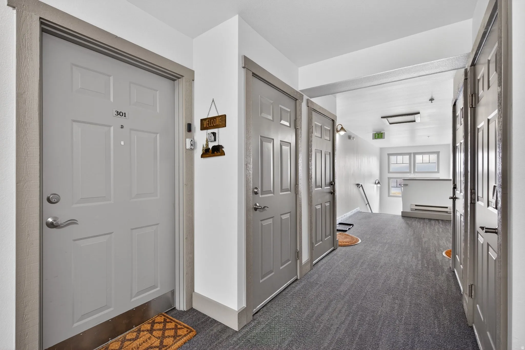 Hallway featuring dark colored carpet and an upstairs landing