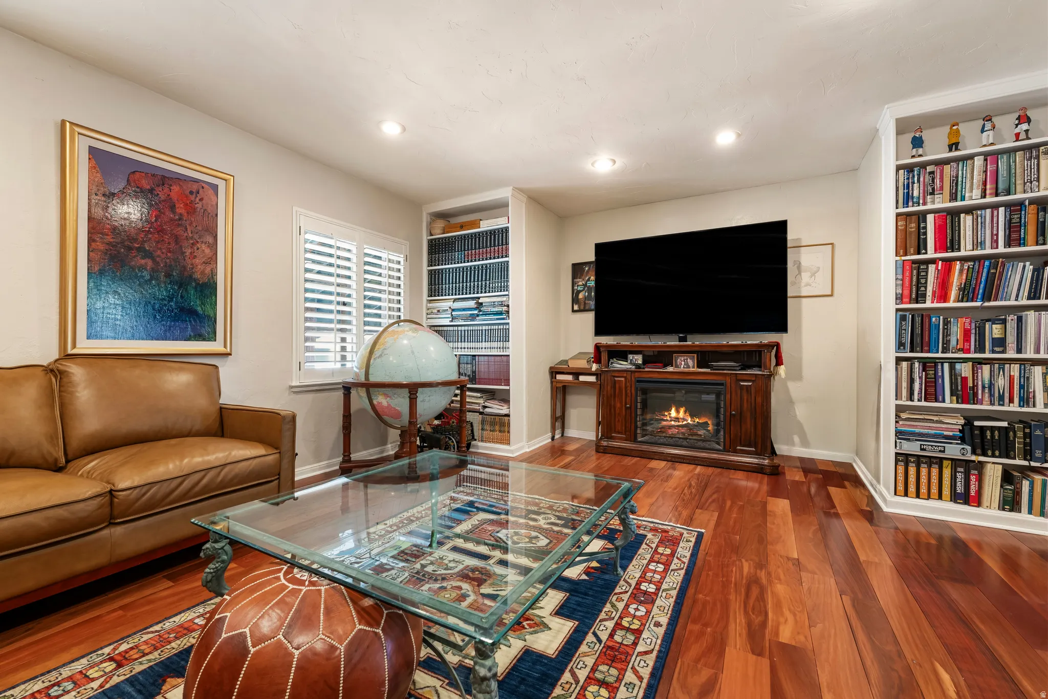 Living area featuring dark wood-type flooring and a glass covered fireplace