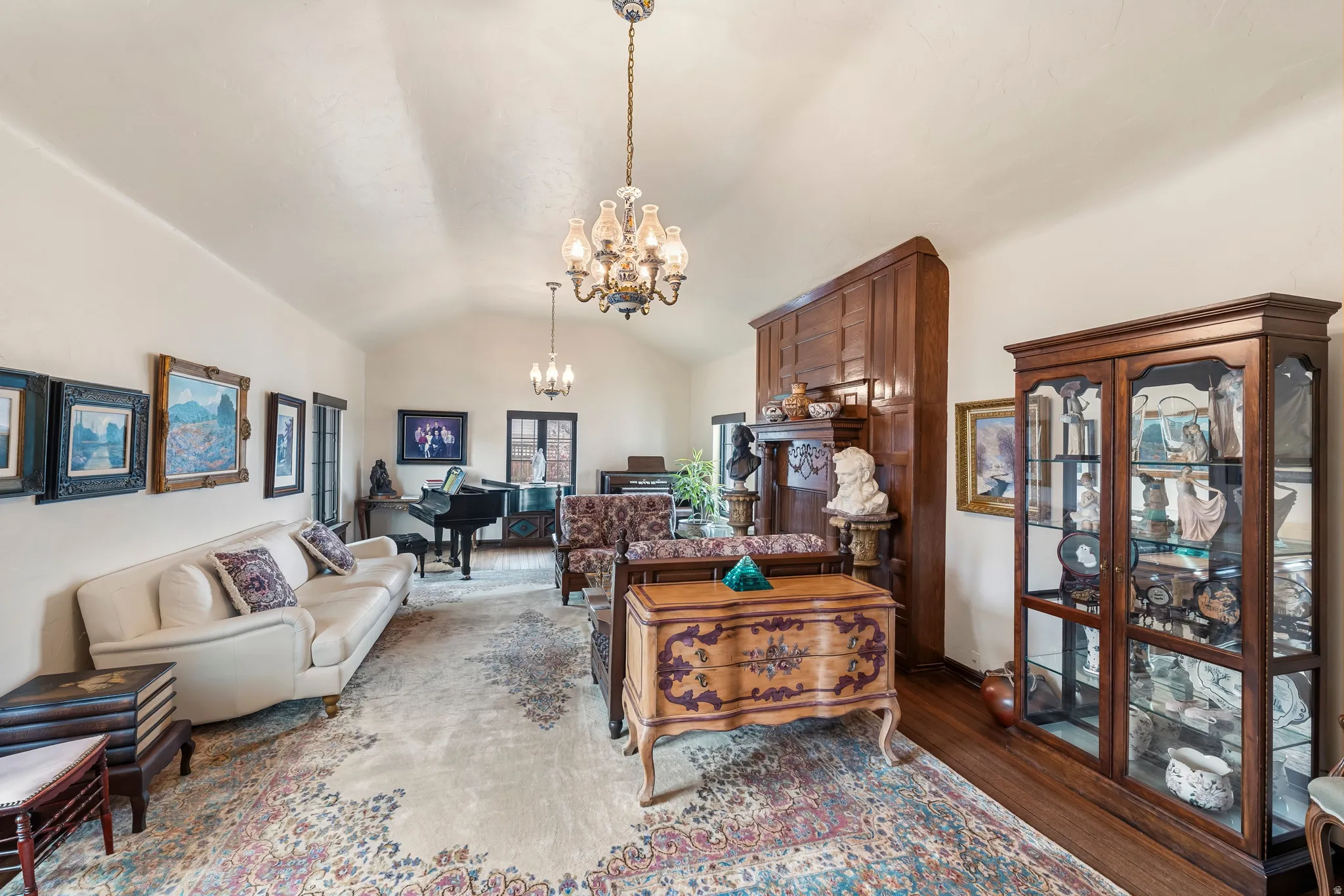 Living area with vaulted ceiling, hanging lights, and wood finished floors